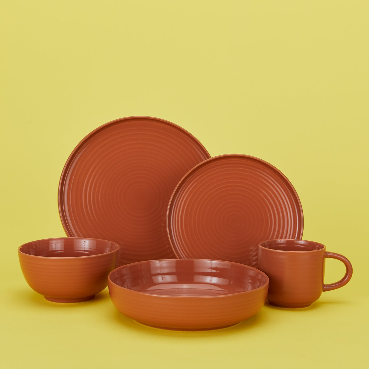 Essential dinnerware set in terracotta with plates bowls and mug