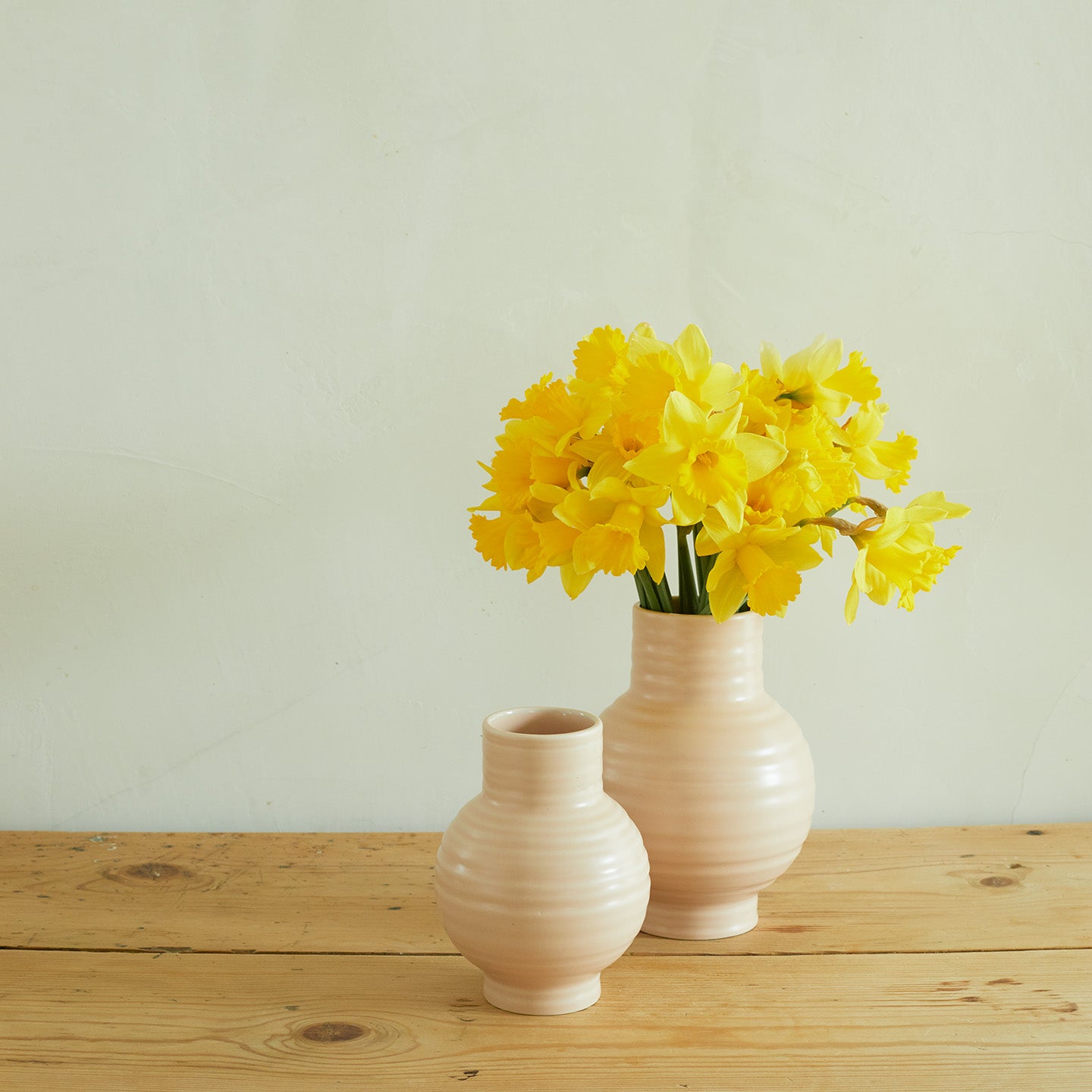 Essential Ceramic Vase in Blush on wood countertop with daffodils.