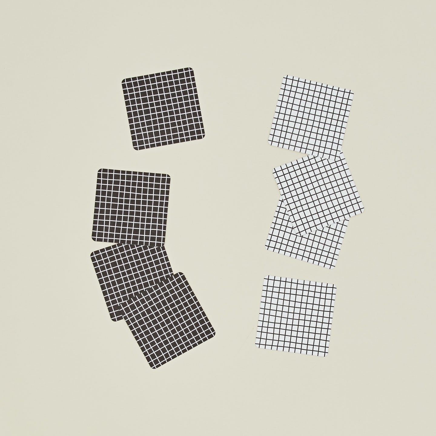 Set of eight reusable gridded paper coasters in two colorways.