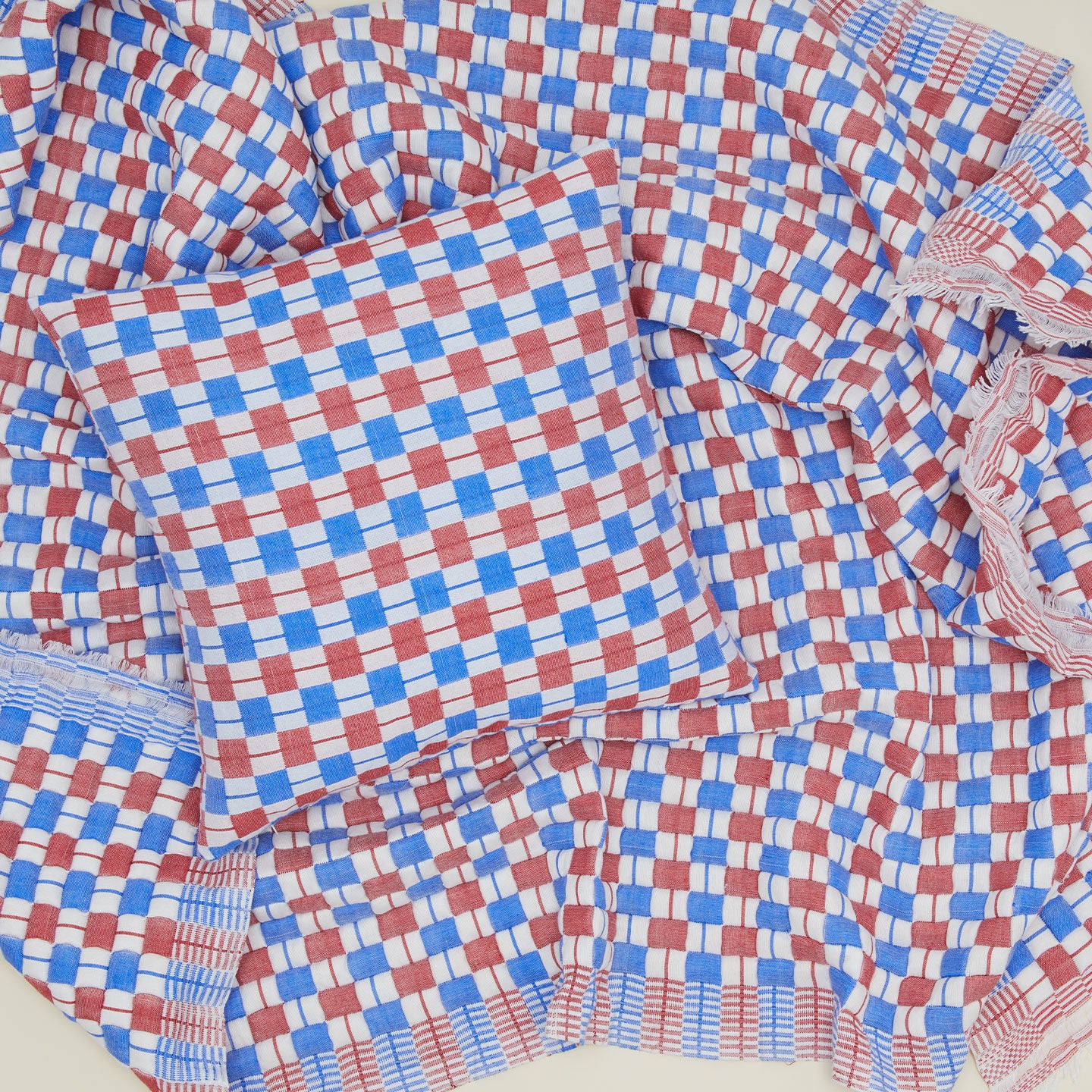 Quilted checkered pillow and throw in red and blue.
