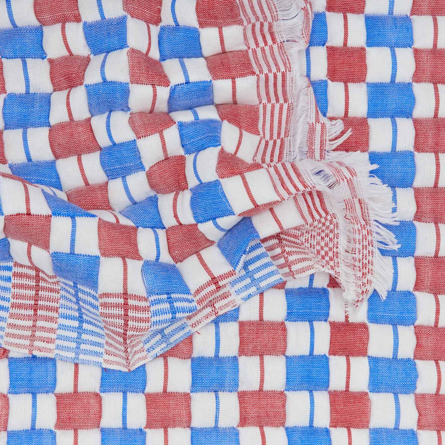 Texture detail of quilted checkered throw in red and blue.
