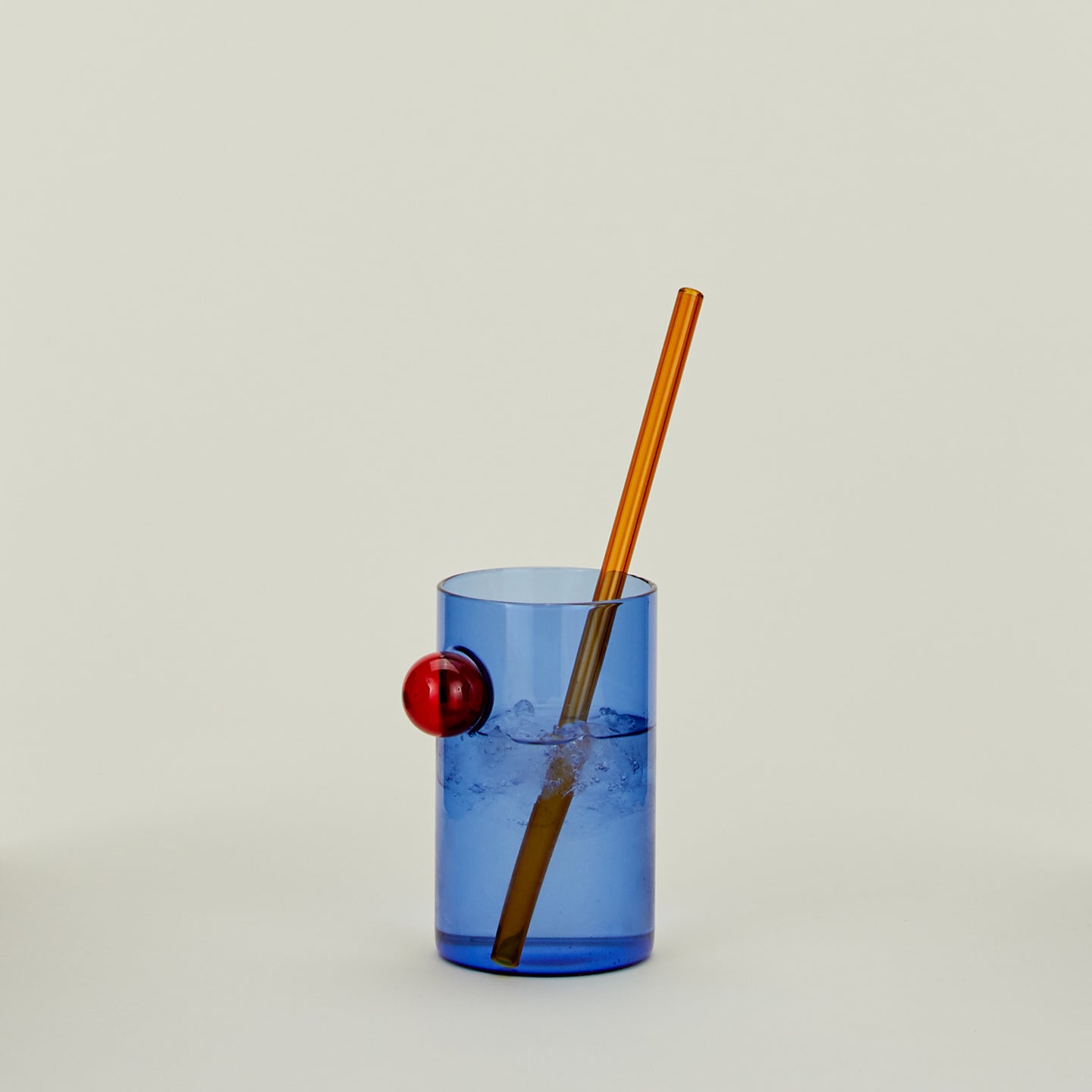 Bubble Glass in Blue with straw, filled with water.
