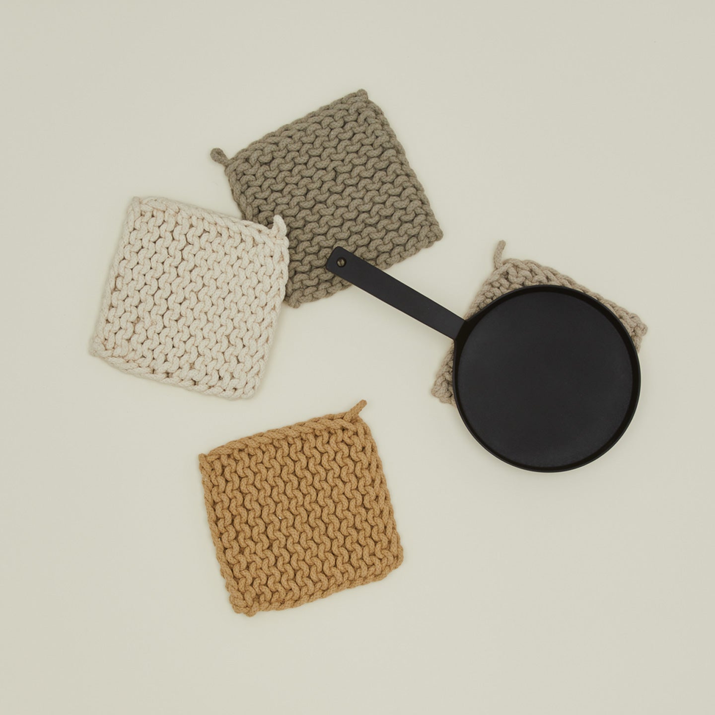 Overhead view of crocheted pot holders in natural colors with pot