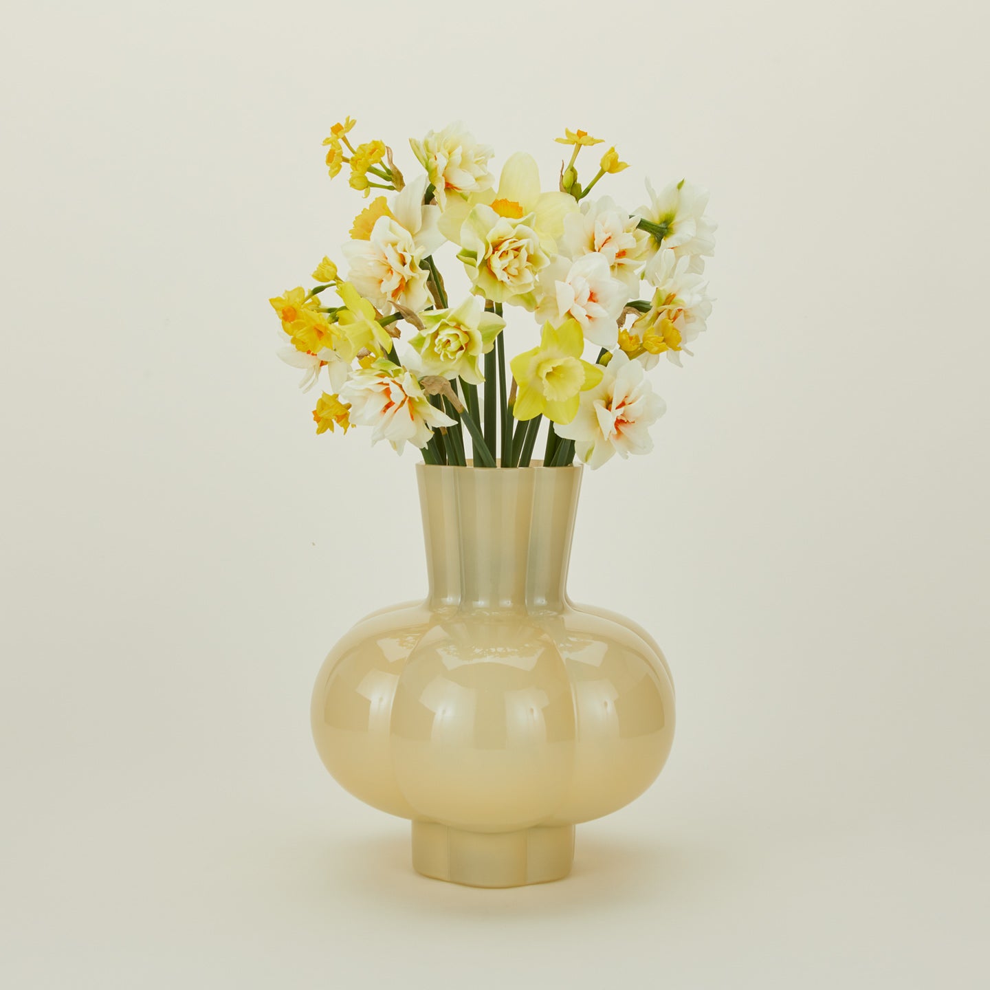 Opaque yellow glass pleated vase with flowers