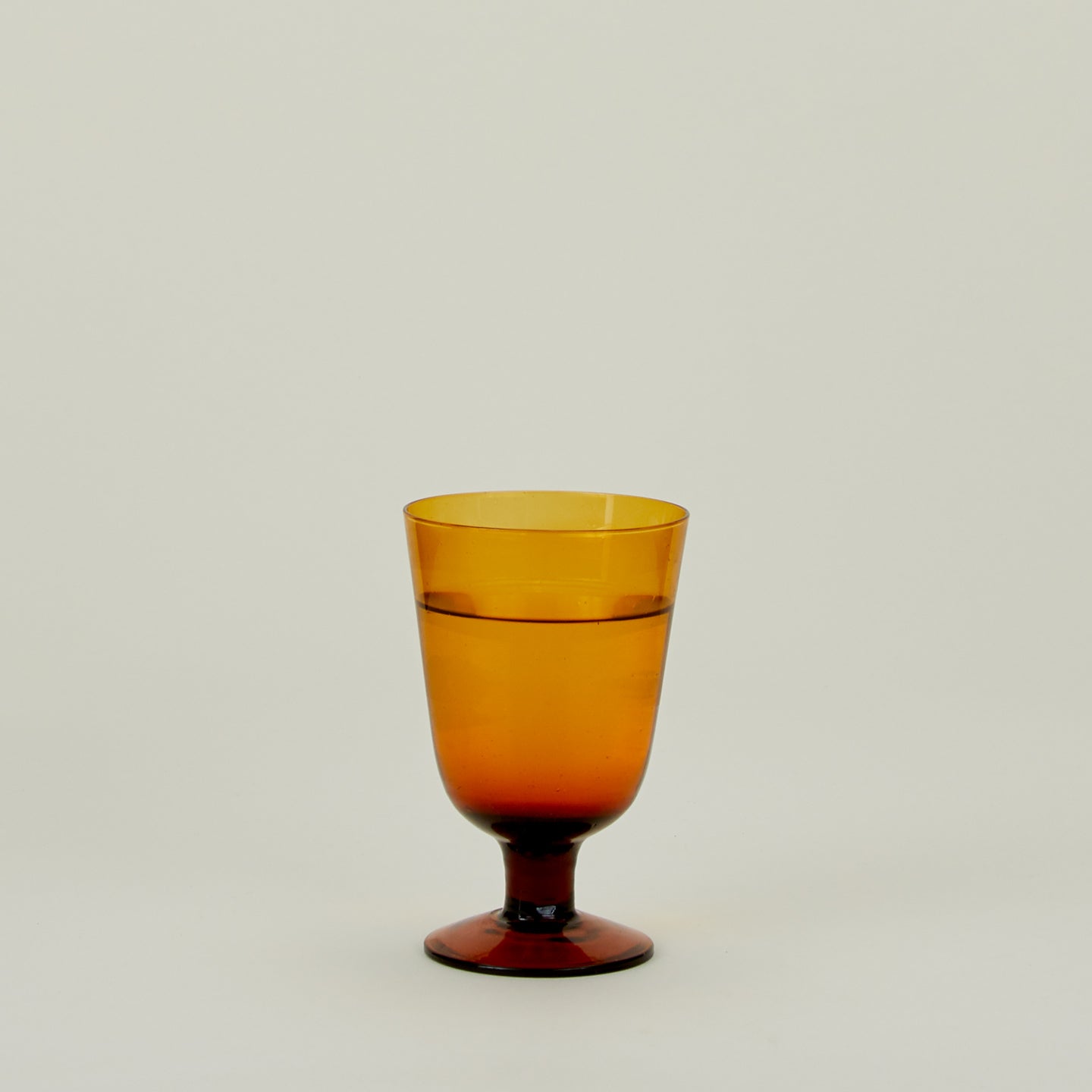Stemmed Wine Glass in Amber, filled with water.