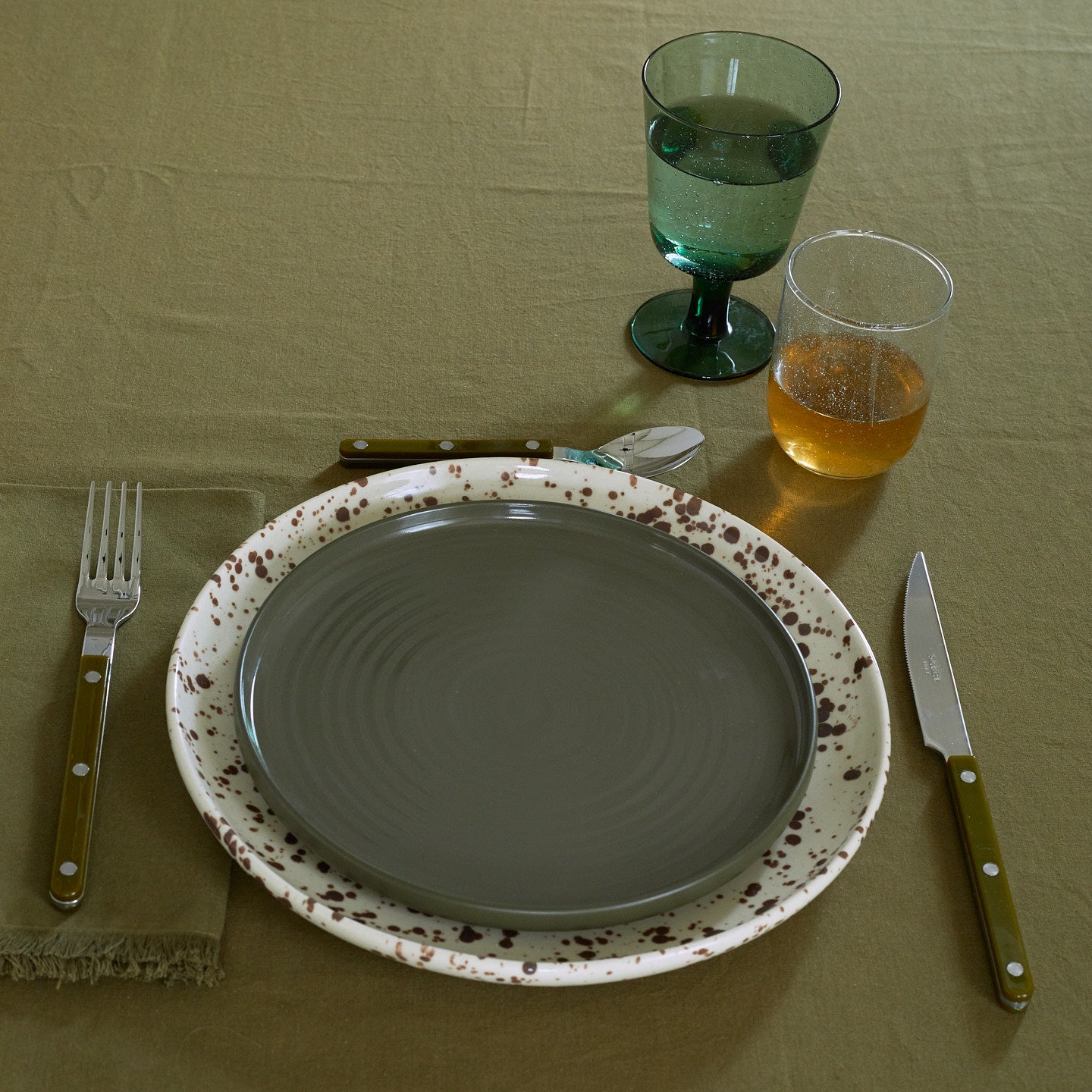 Placesetting with Stemmed Wine Glass in Jade on green tablecloth.