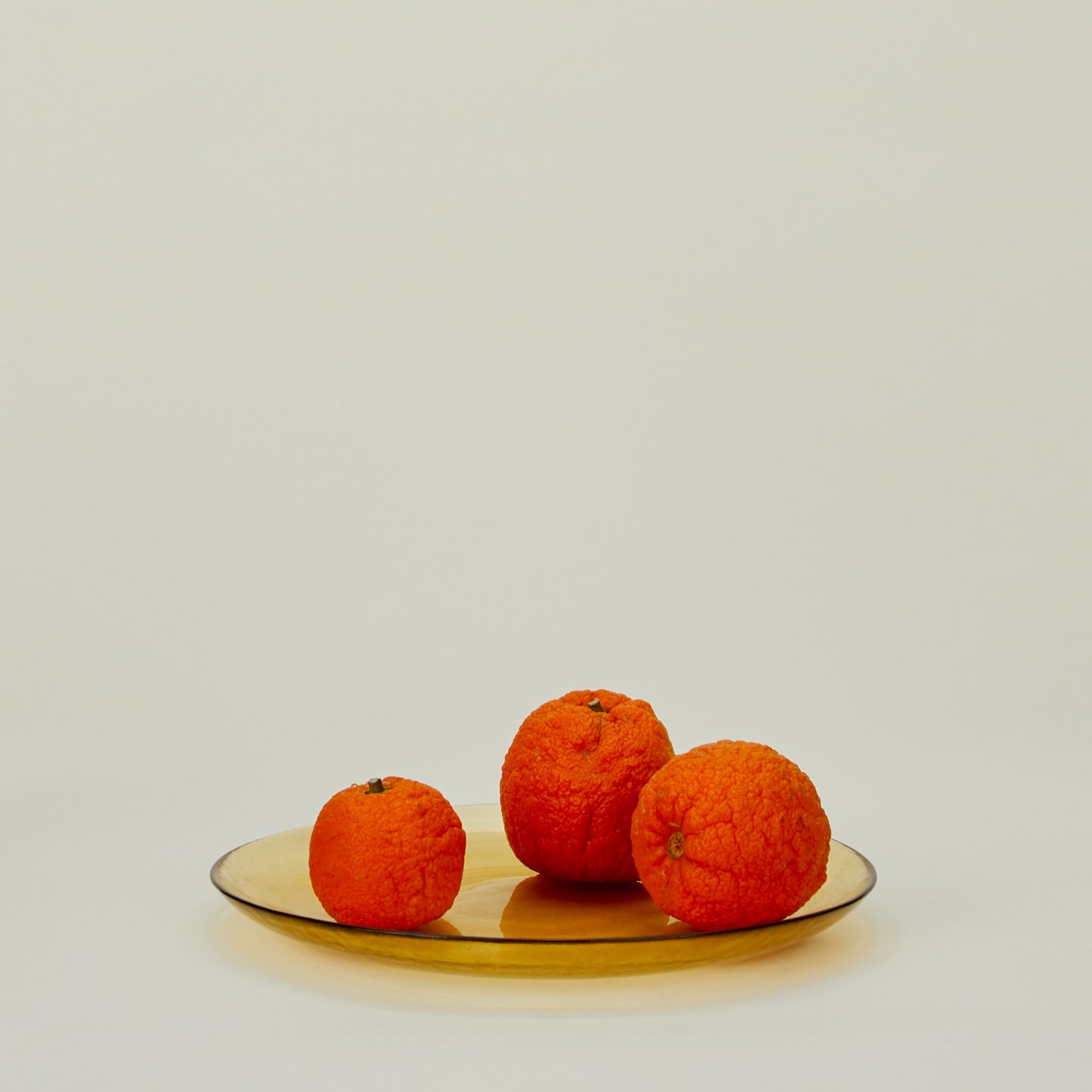 Glass Dinner Plate in Amber, with oranges.