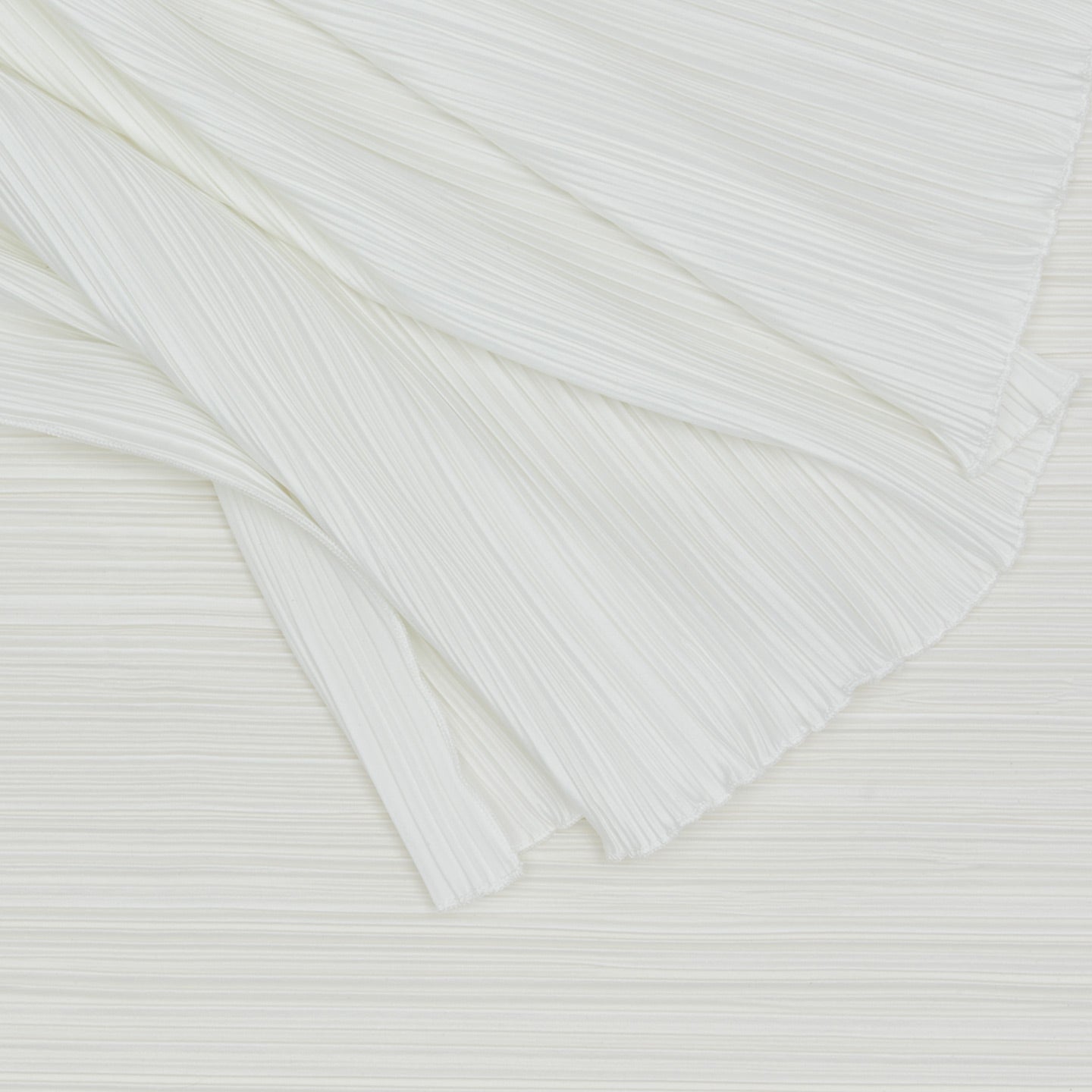Close up view of Cahaya pleated tablecloth in ivory