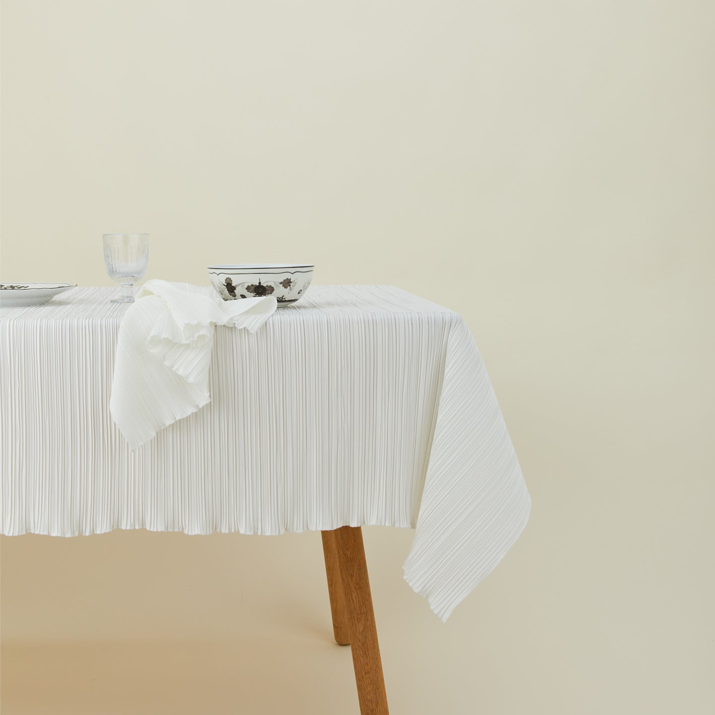 Cahaya tablecloth in ivory on table with napkin, bowl, stemware, and plate