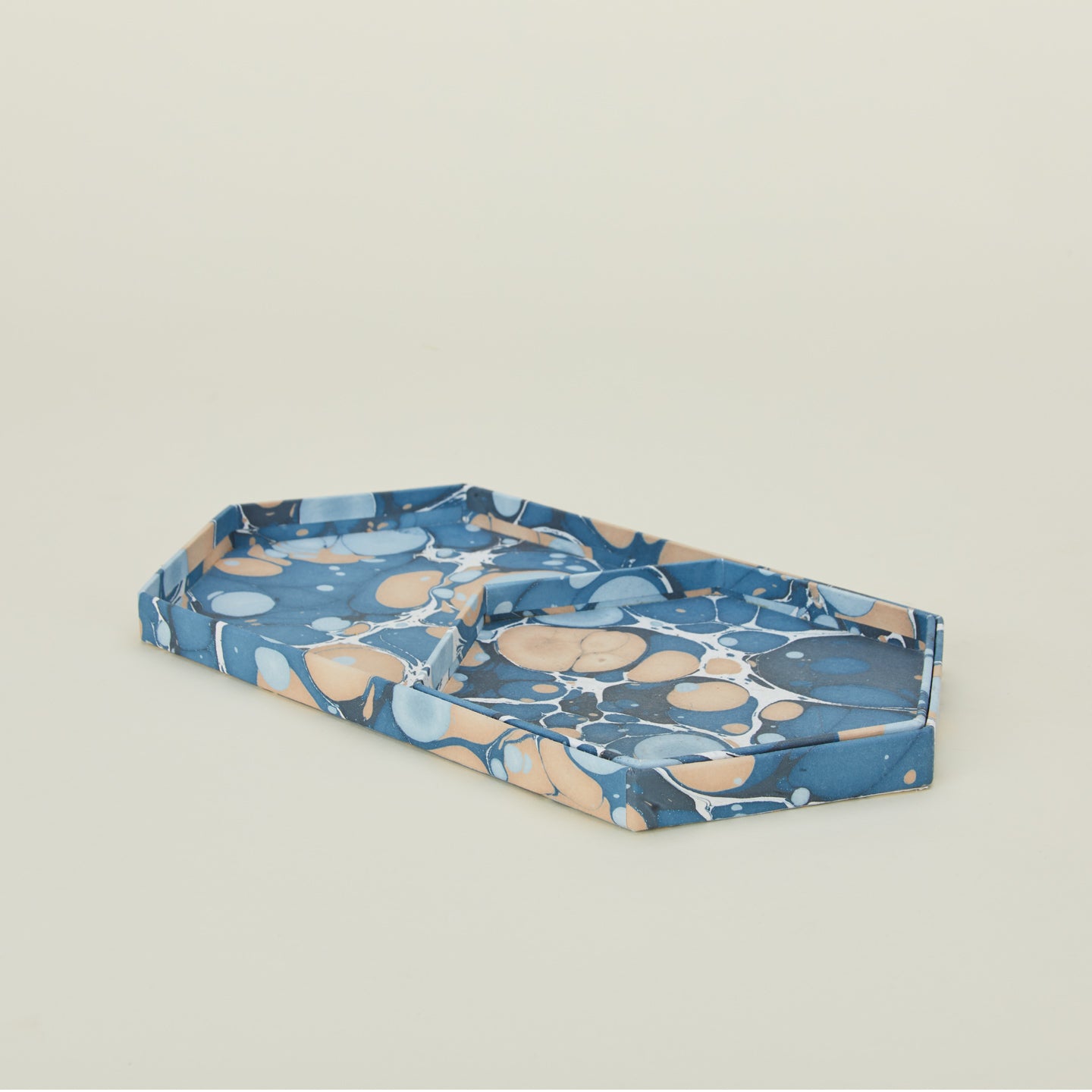 Detail view of two hexagon marbled trays in cool tones.