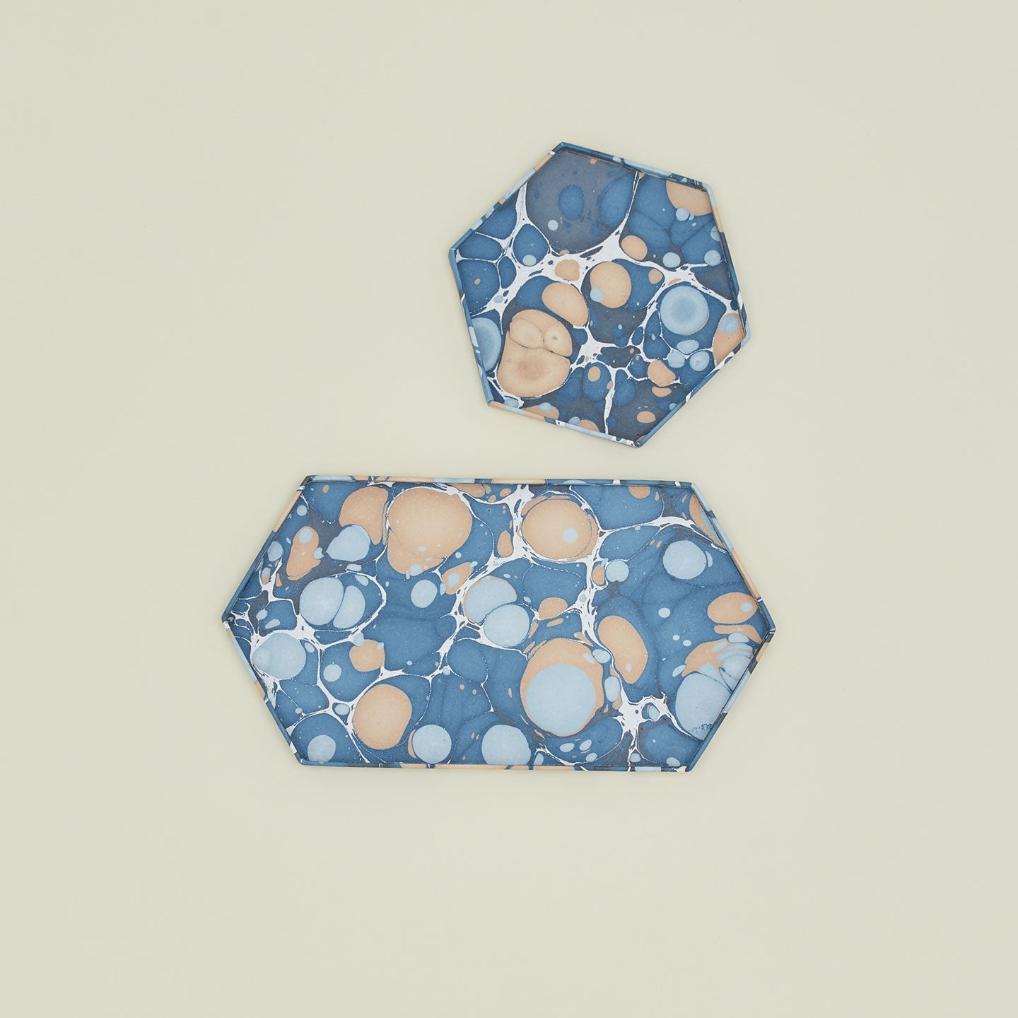 Overhead view of two hexagon marbled trays in cool tones.
