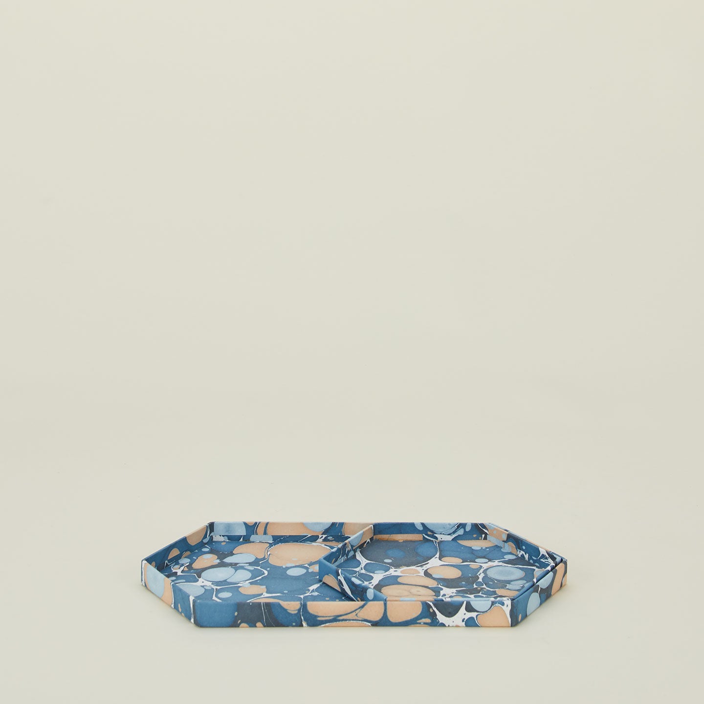 Set of two nested hexagon marbled trays in cool tones.