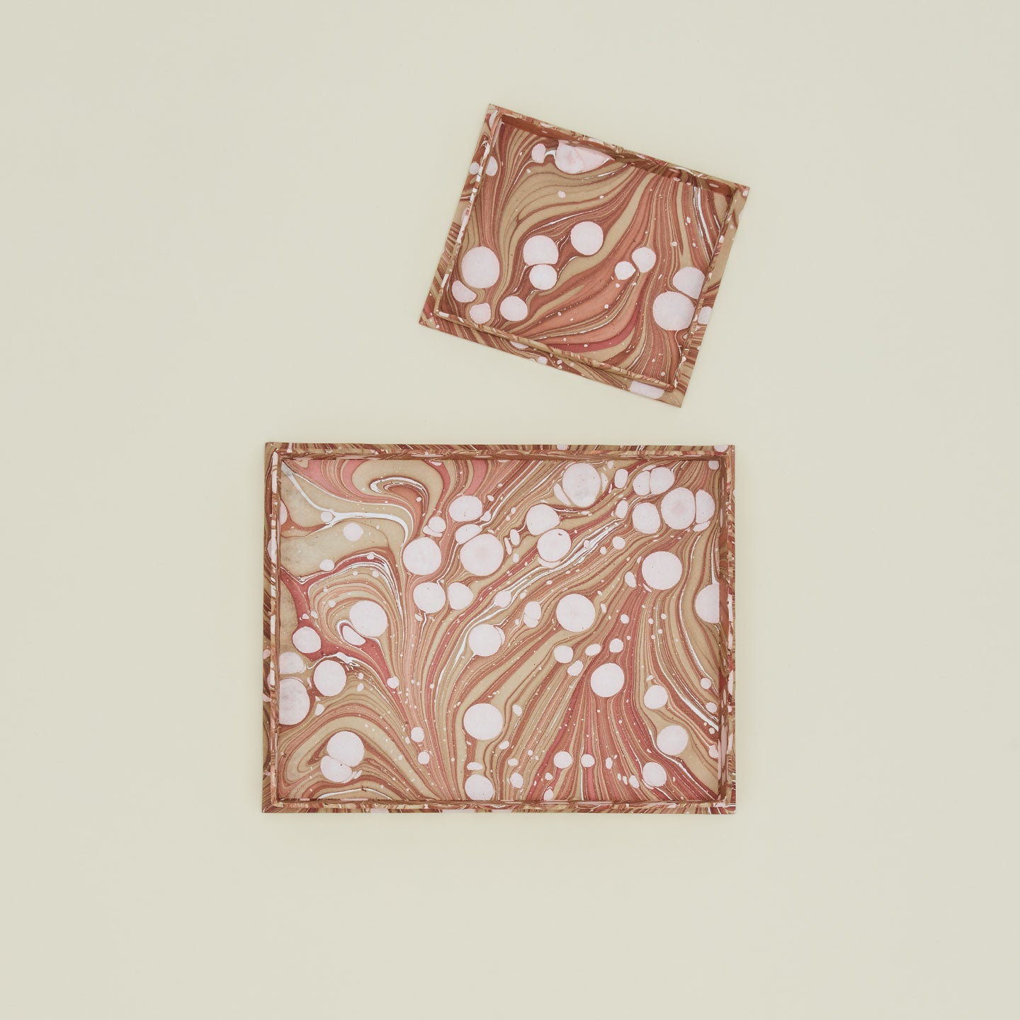 Overhead view of two scalloped marbled trays in mocha.