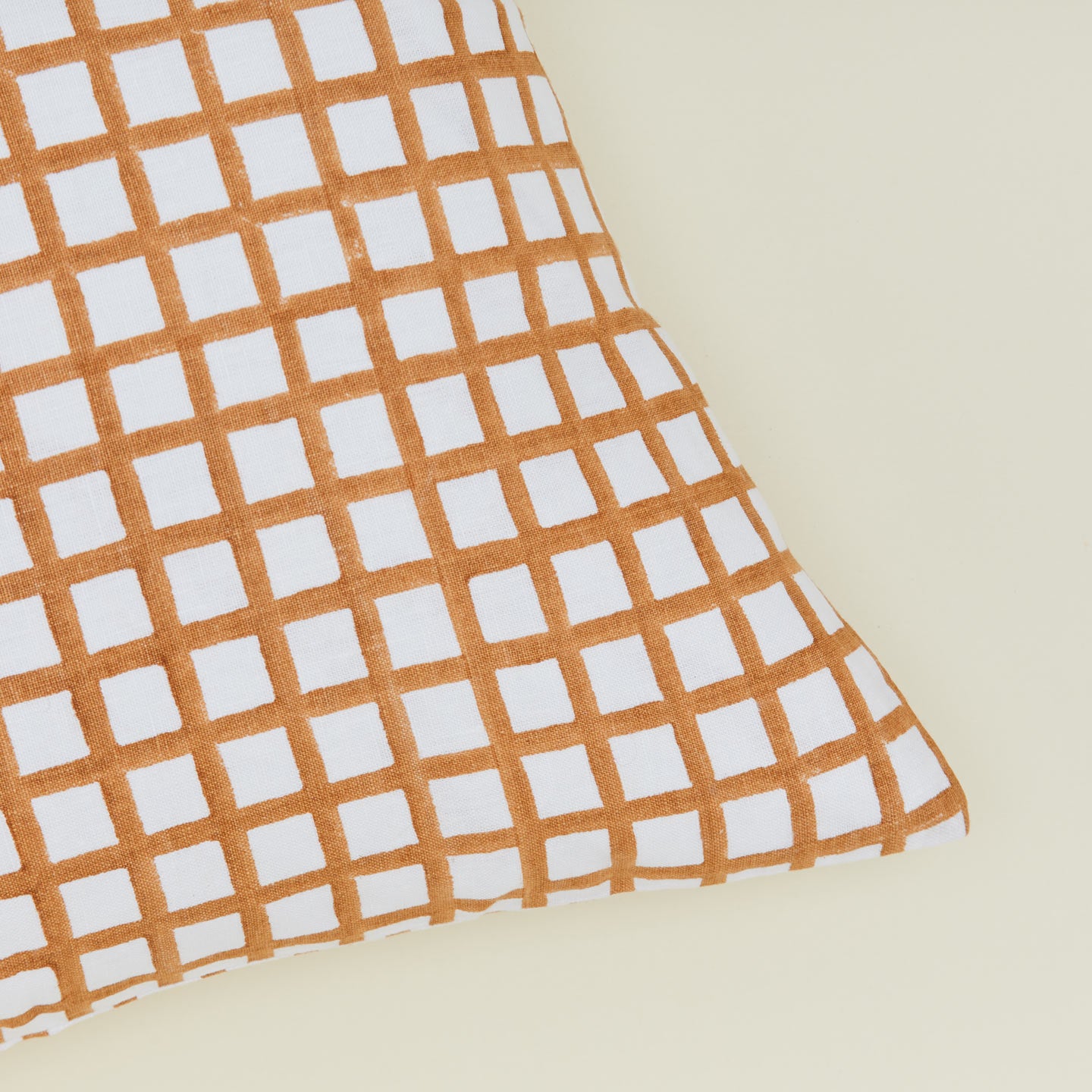 Detail of block printed grid pillow in Ochre.
