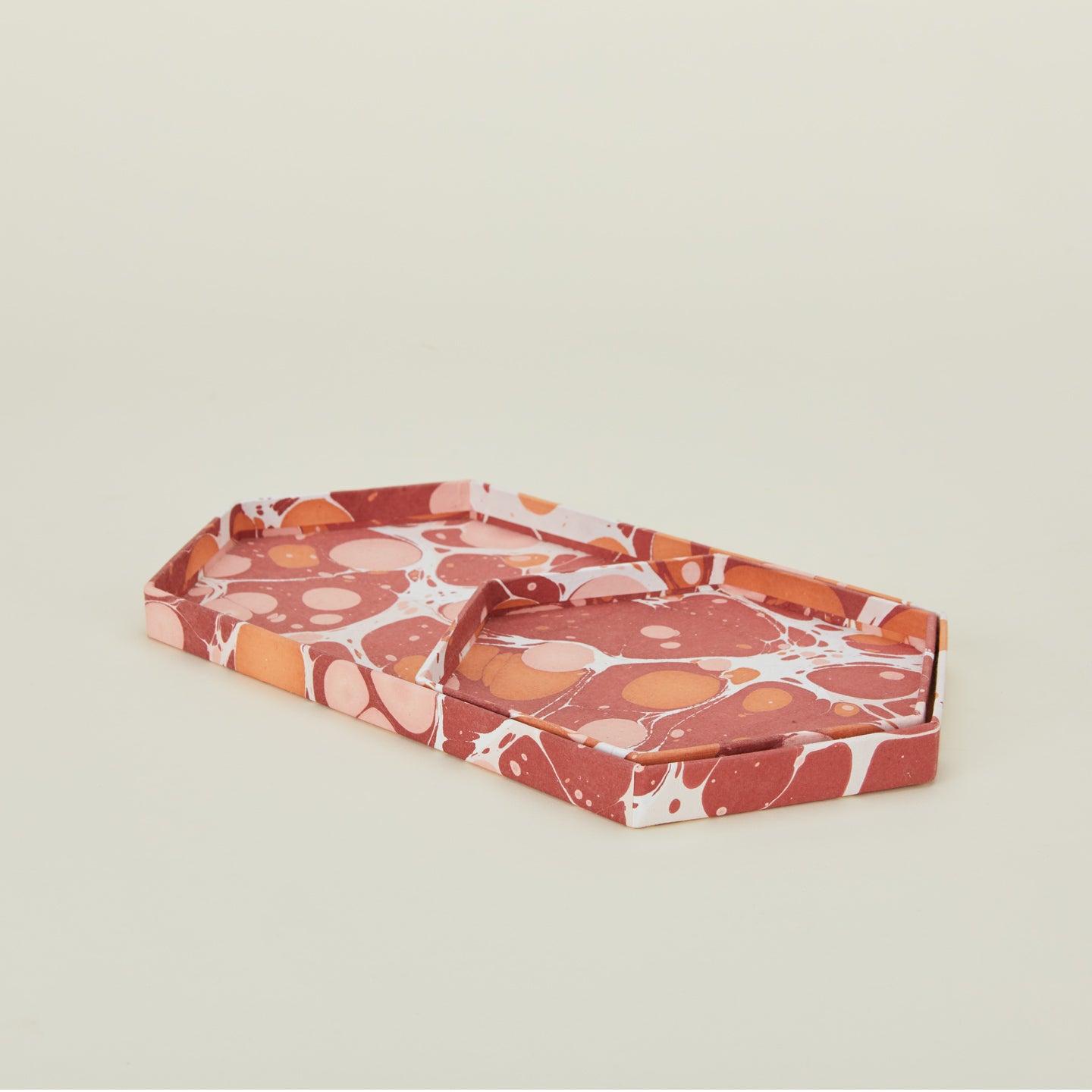 Detail view of two hexagon marbled trays in warm tones.