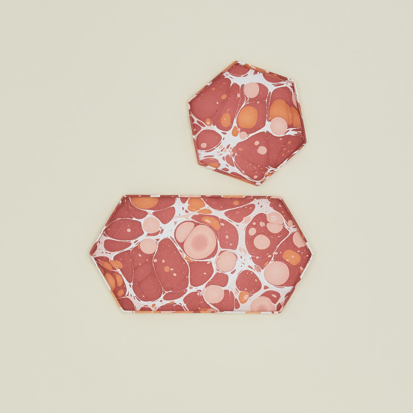 Overhead view of two hexagon marbled trays in warm tones.