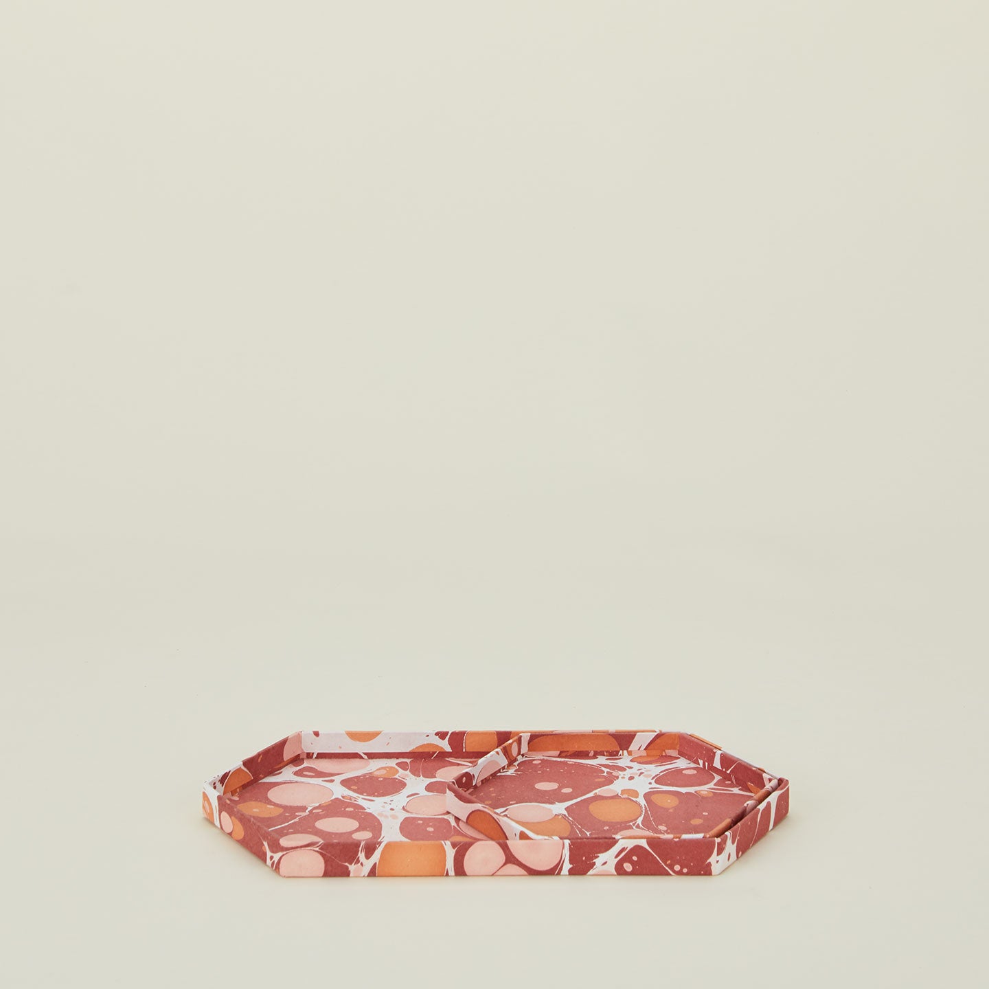 Set of two nested hexagon marbled trays in warm tones.
