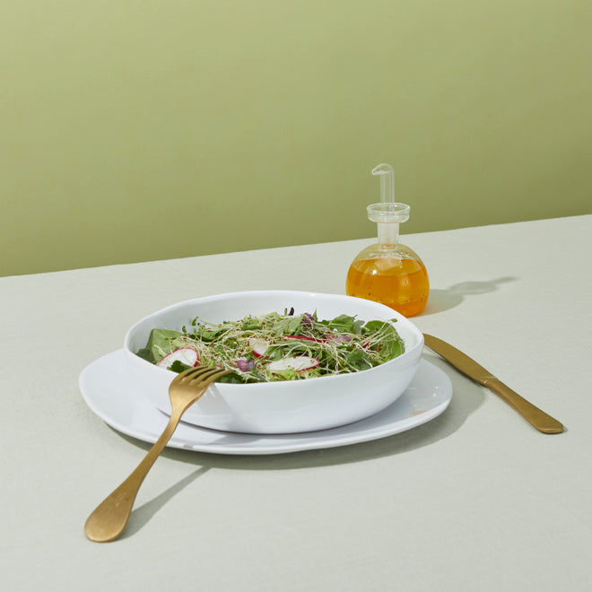 Organic low bowl with salad, Hudson flatware and Essential Kitchen bottle.