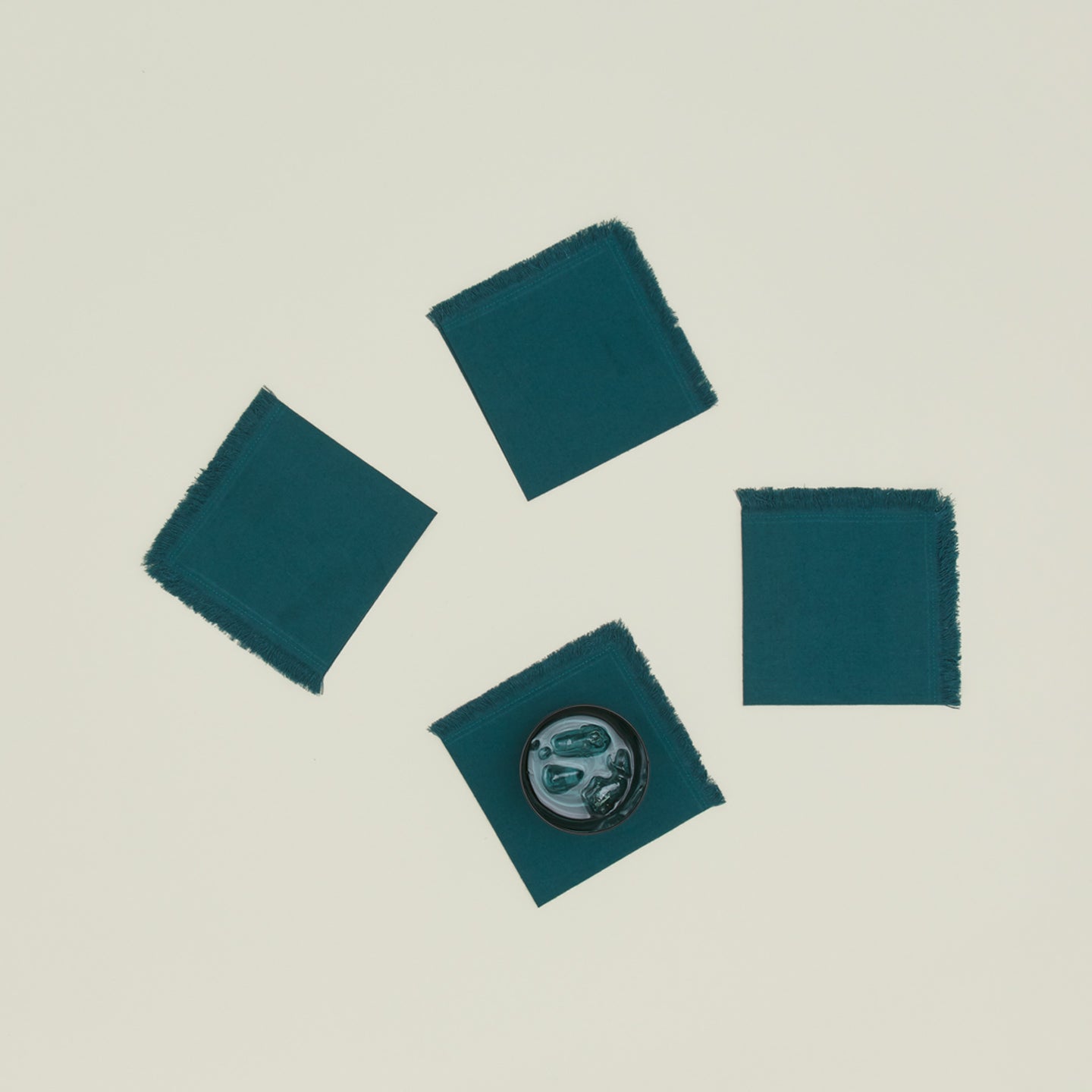 Essential Cocktail Napkins in Peacock with glass.