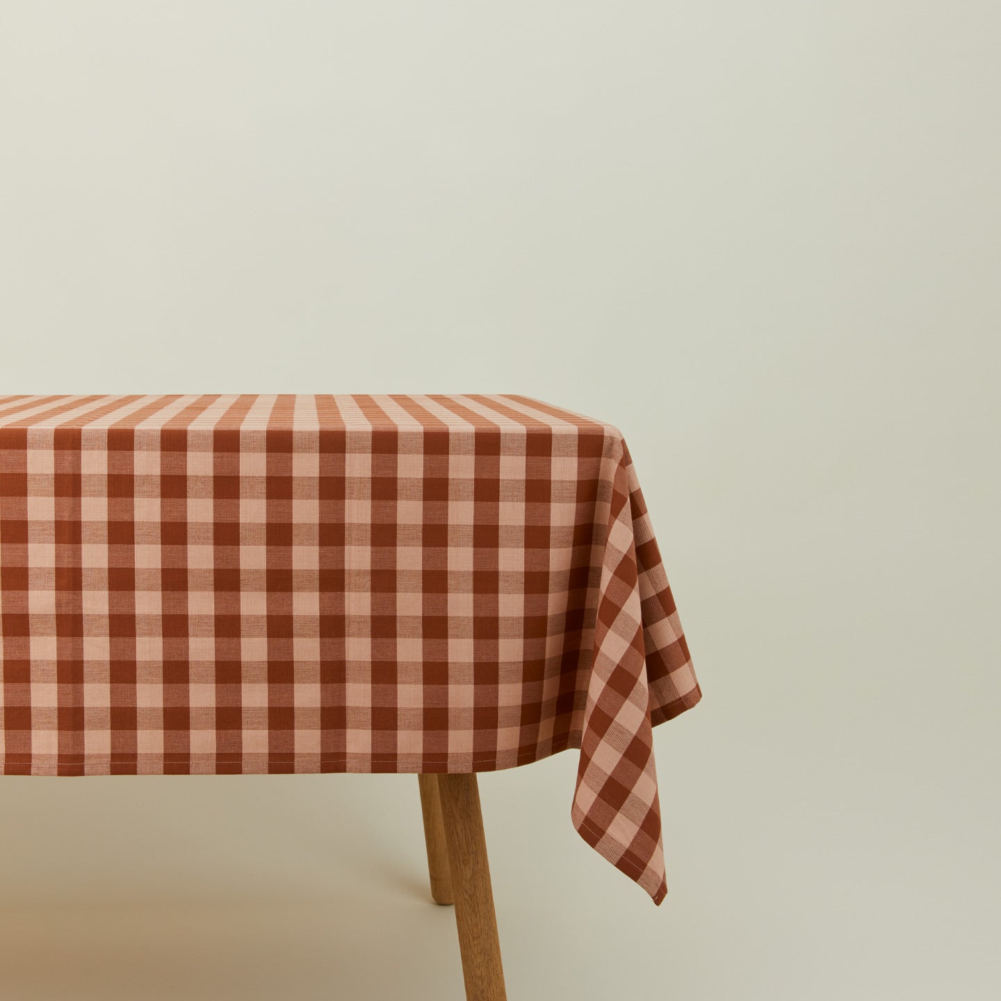 Essential Gingham tablecloth in blush/terracotta on a table.