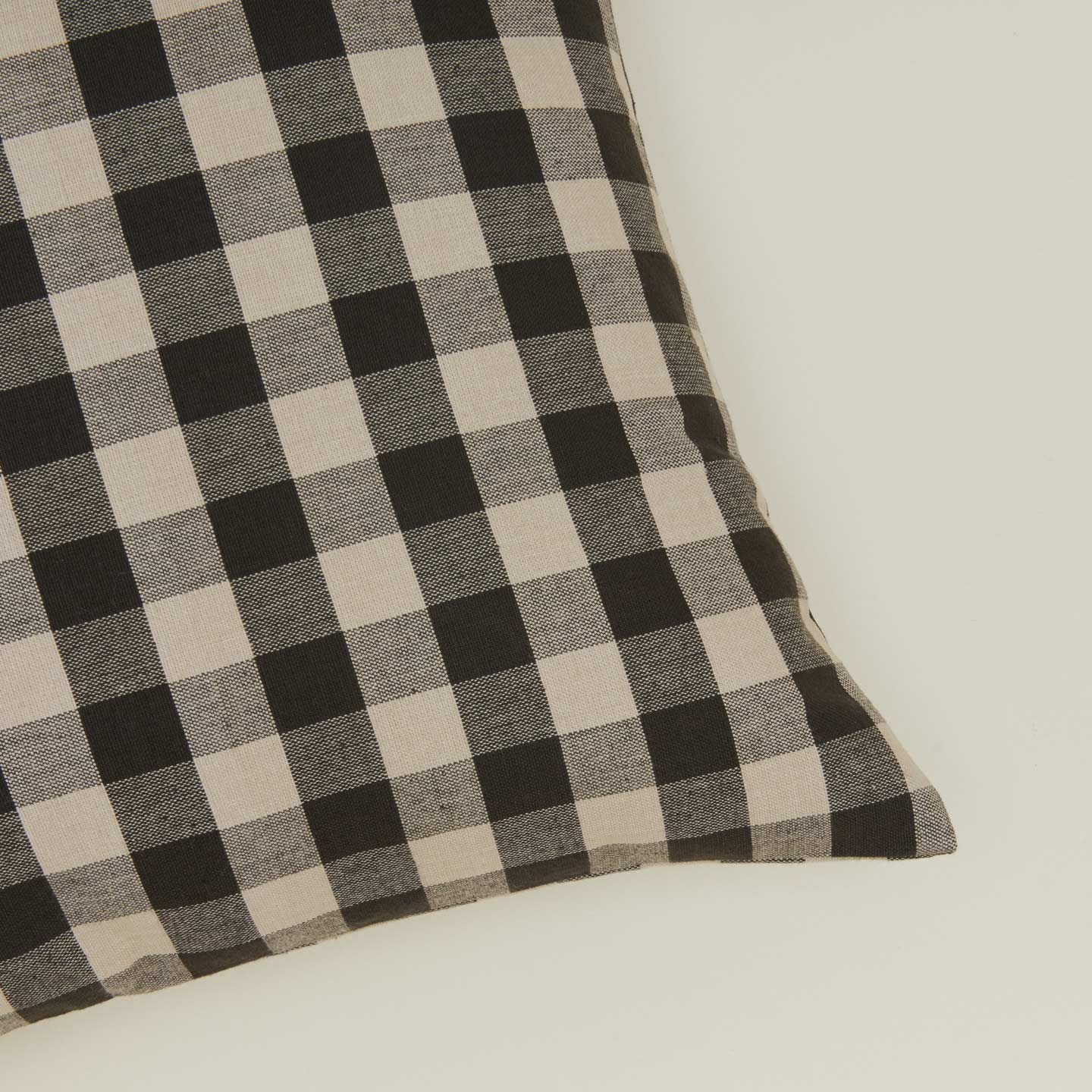 Close up view of gingham square pillow in grey/black