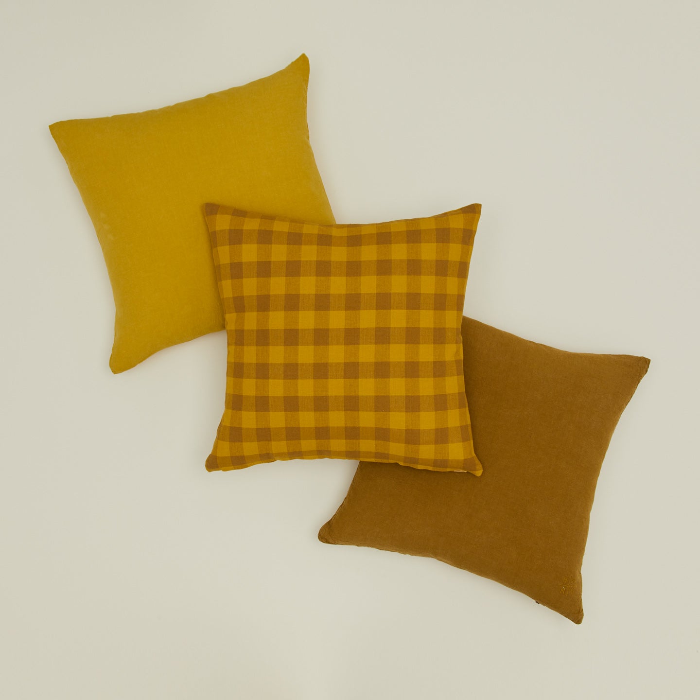 Essential gingham pillow and simple linen pillows in mustard and bronze