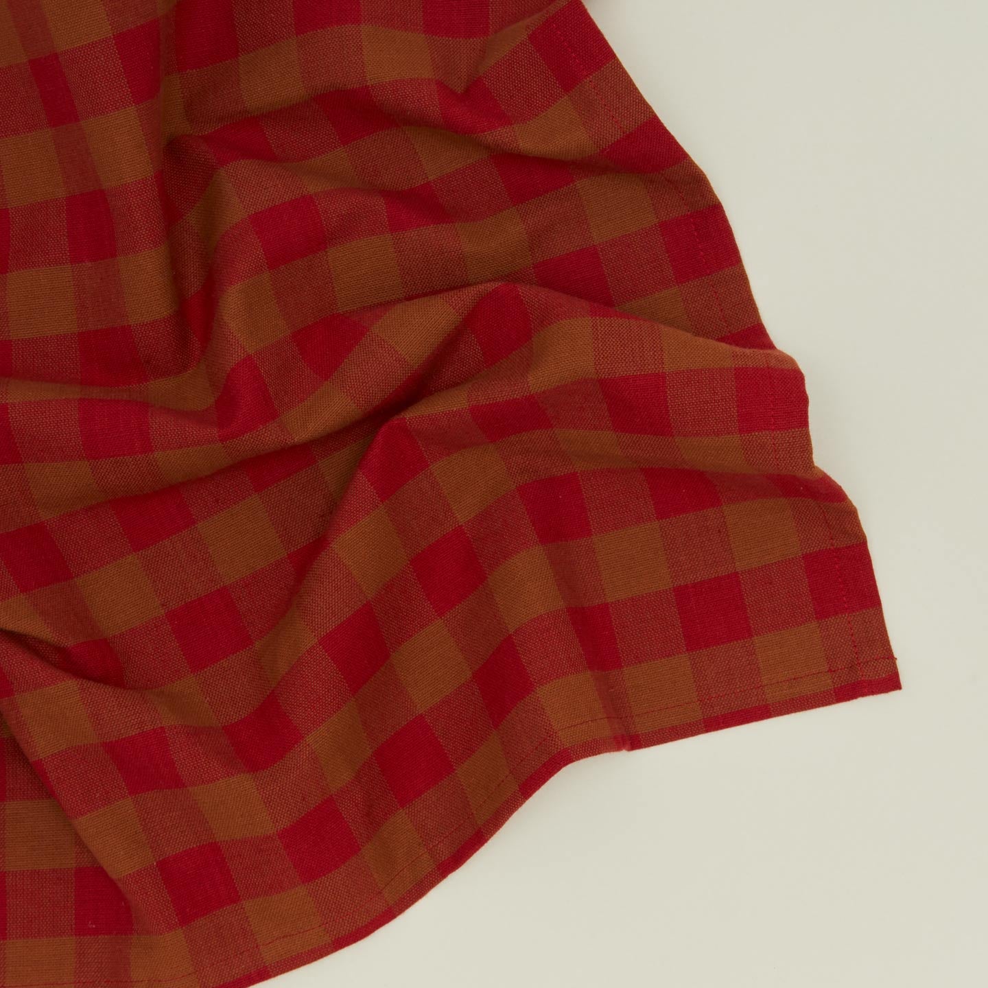 Close up view of Essential Gingham napkin in red/terracotta