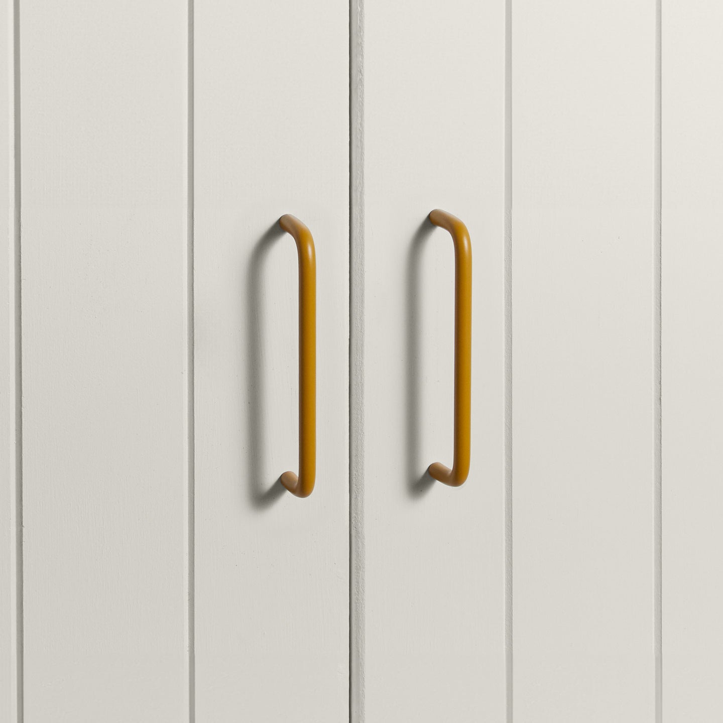 Large mustard pulls on white doors