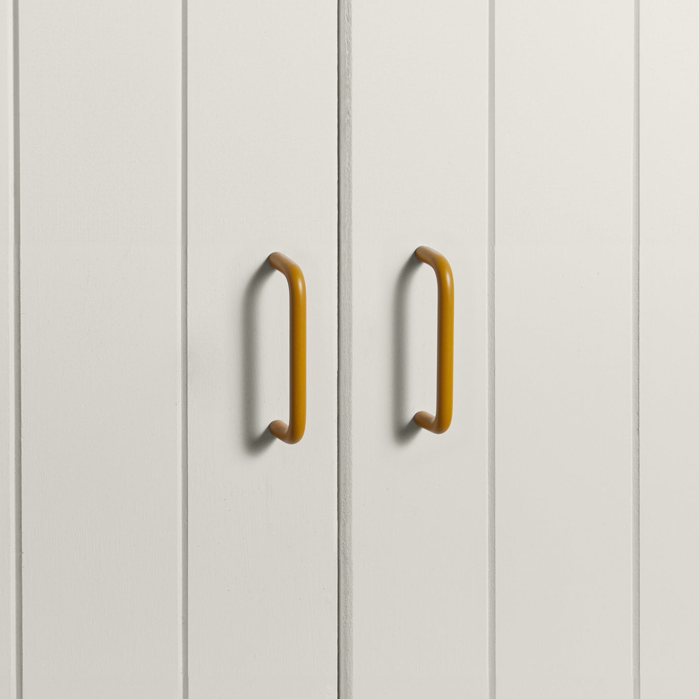 Small mustard pulls on white doors