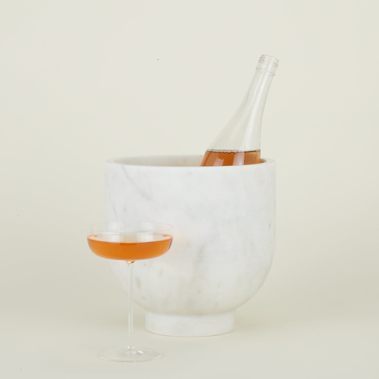 Alza Champagne Cooler holding wine bottle and coupe glass filled with sparkling wine.