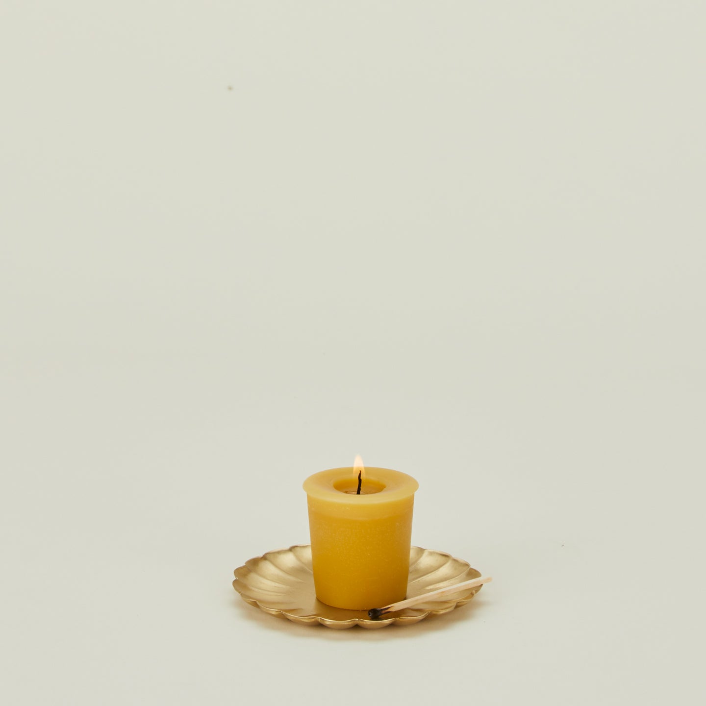 Small brass petal plate with lit votive