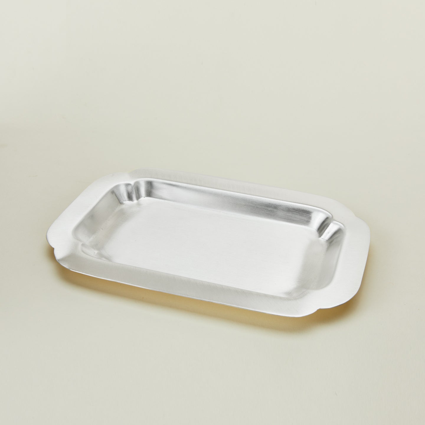 Three quarter view of of decorative edge rectangular silver tray