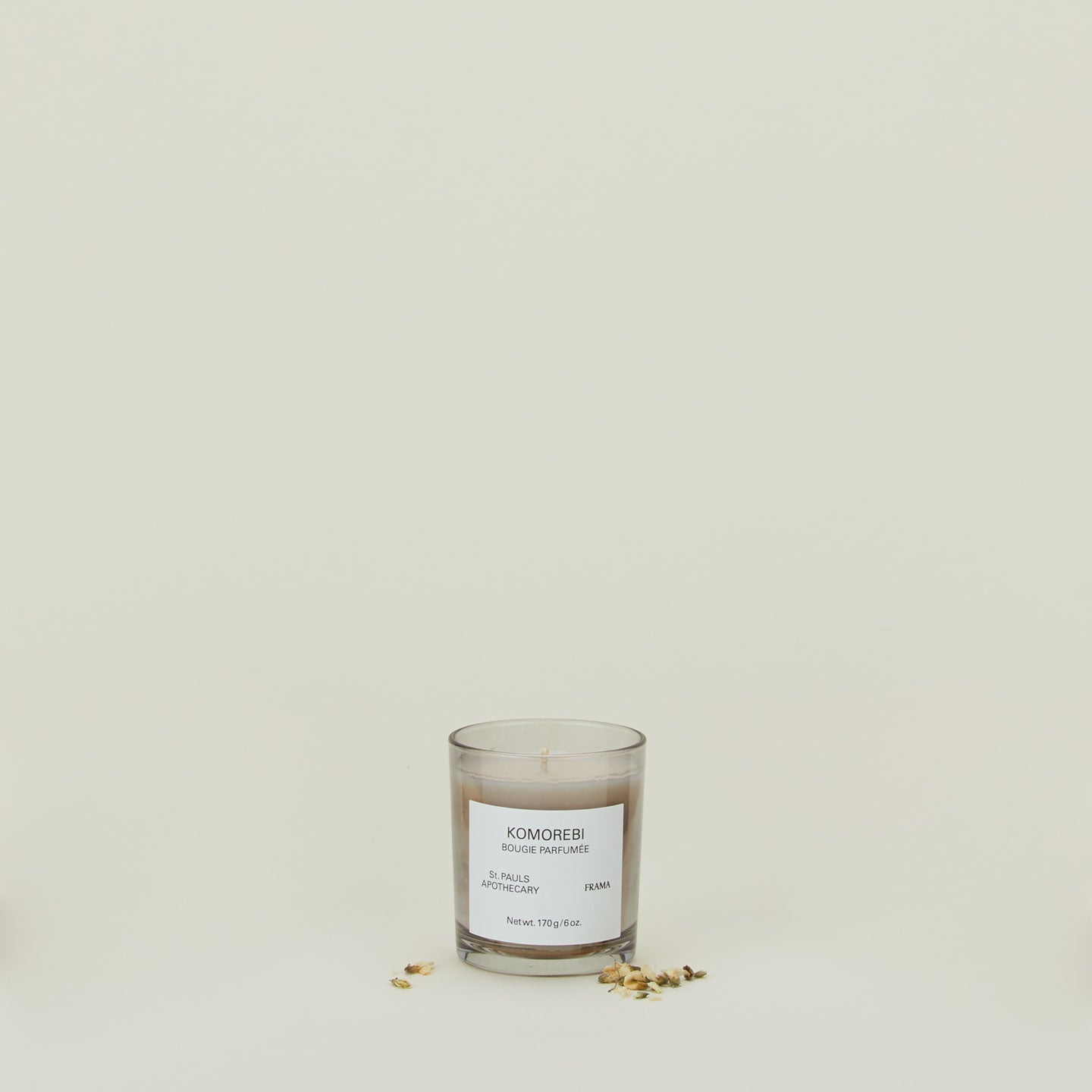 A wax candle with the scent Komorebi, with dried florals.