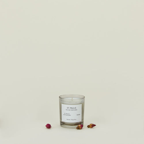 A wax candle with the scent St. Pauls, with dried florals.