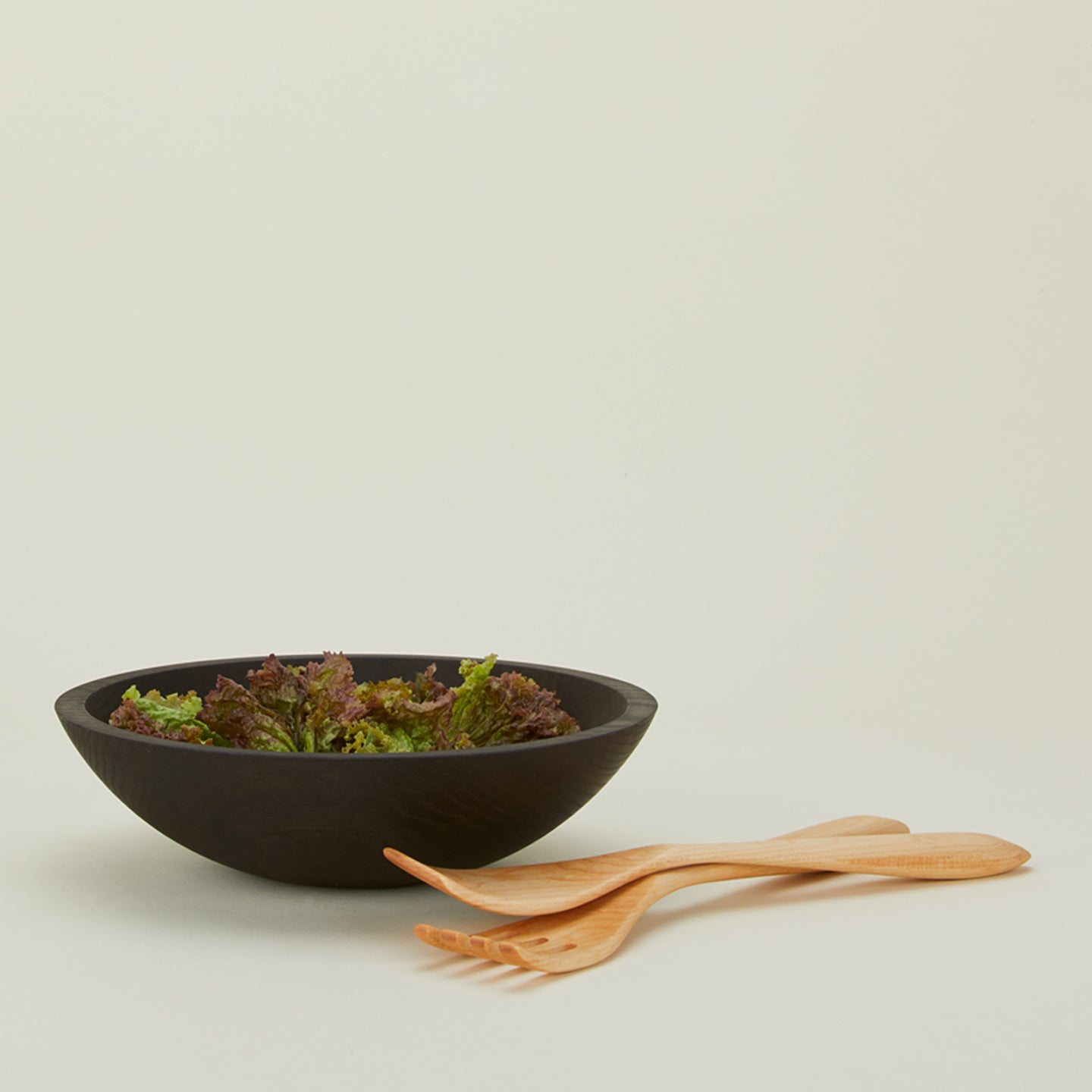 Salad servers in maple with wooden bowl and arugula