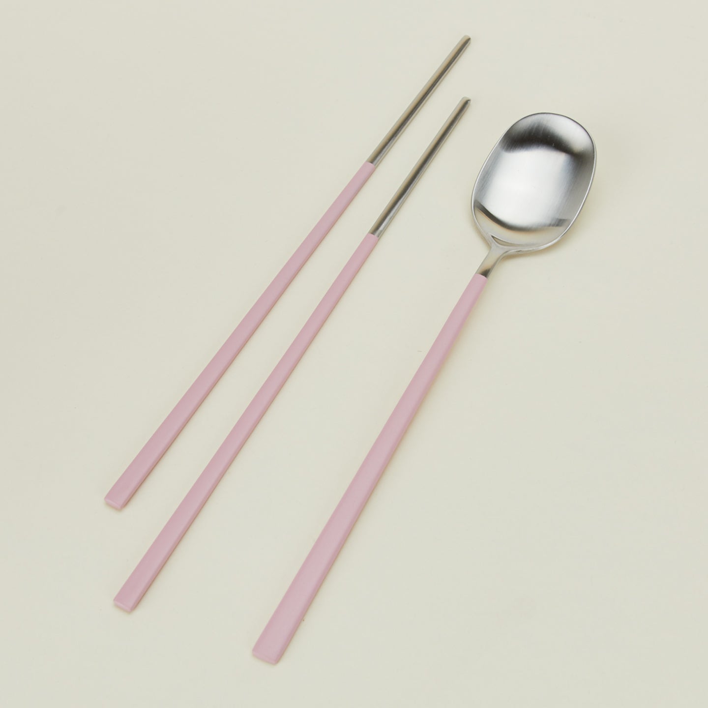 Close up view of Illo spoon and chopstick set in pink