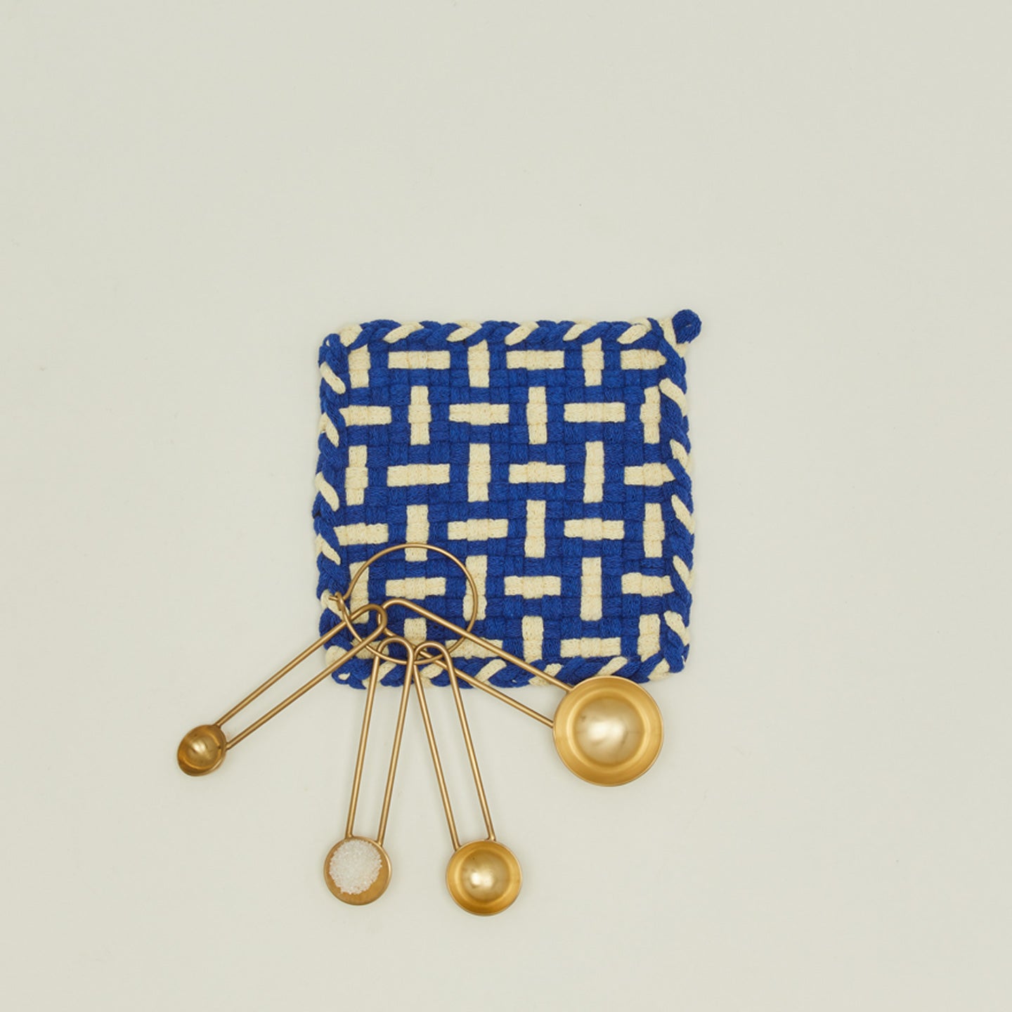 Parquet potholder in blue and yellow with brass measuring spoons