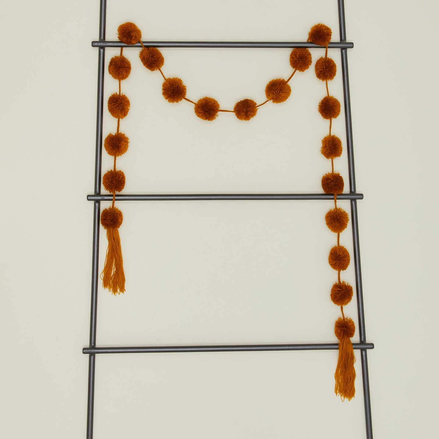 Magic pom pom garland in gold on ladder