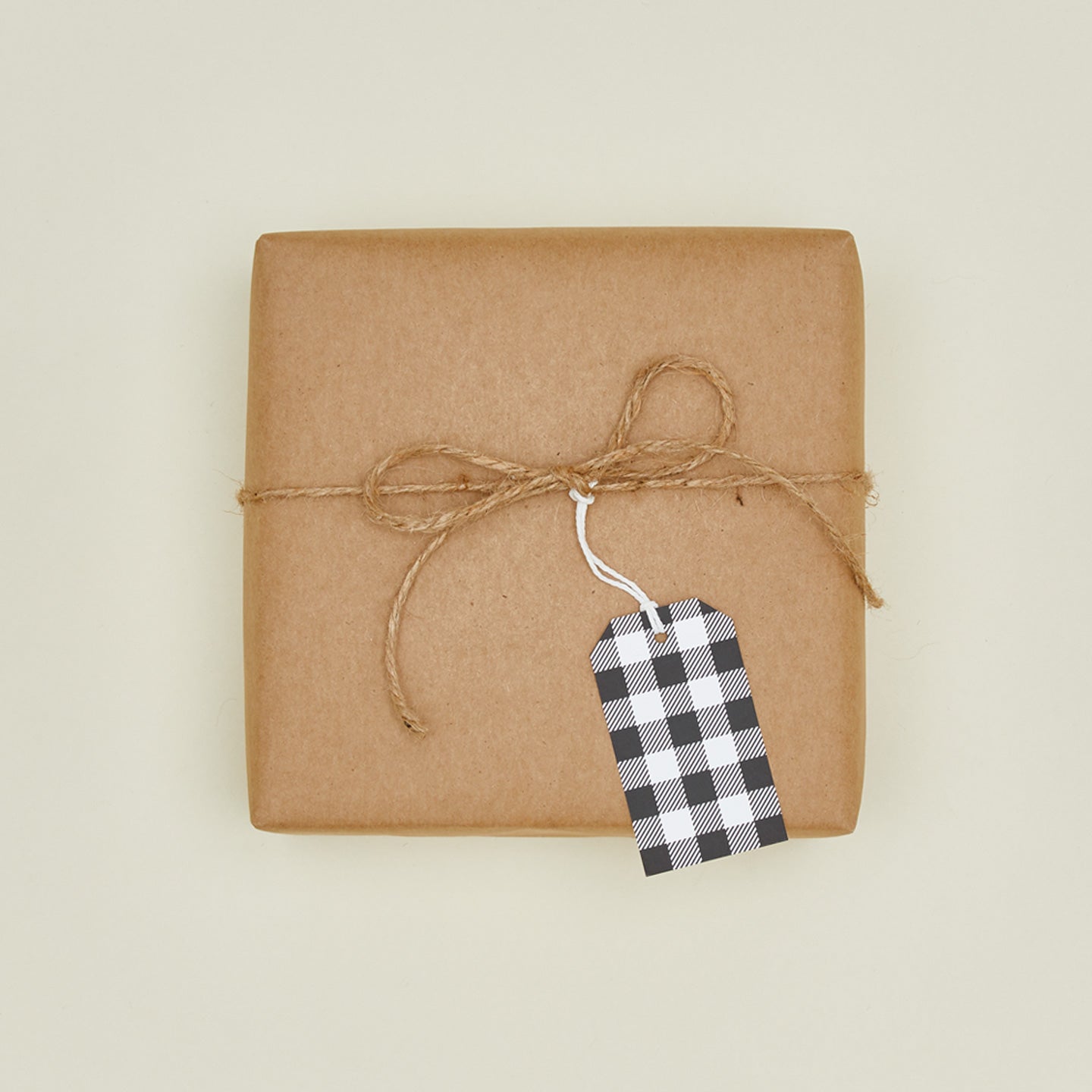 Buffalo plaid gift tag on box wrapped in craft paper