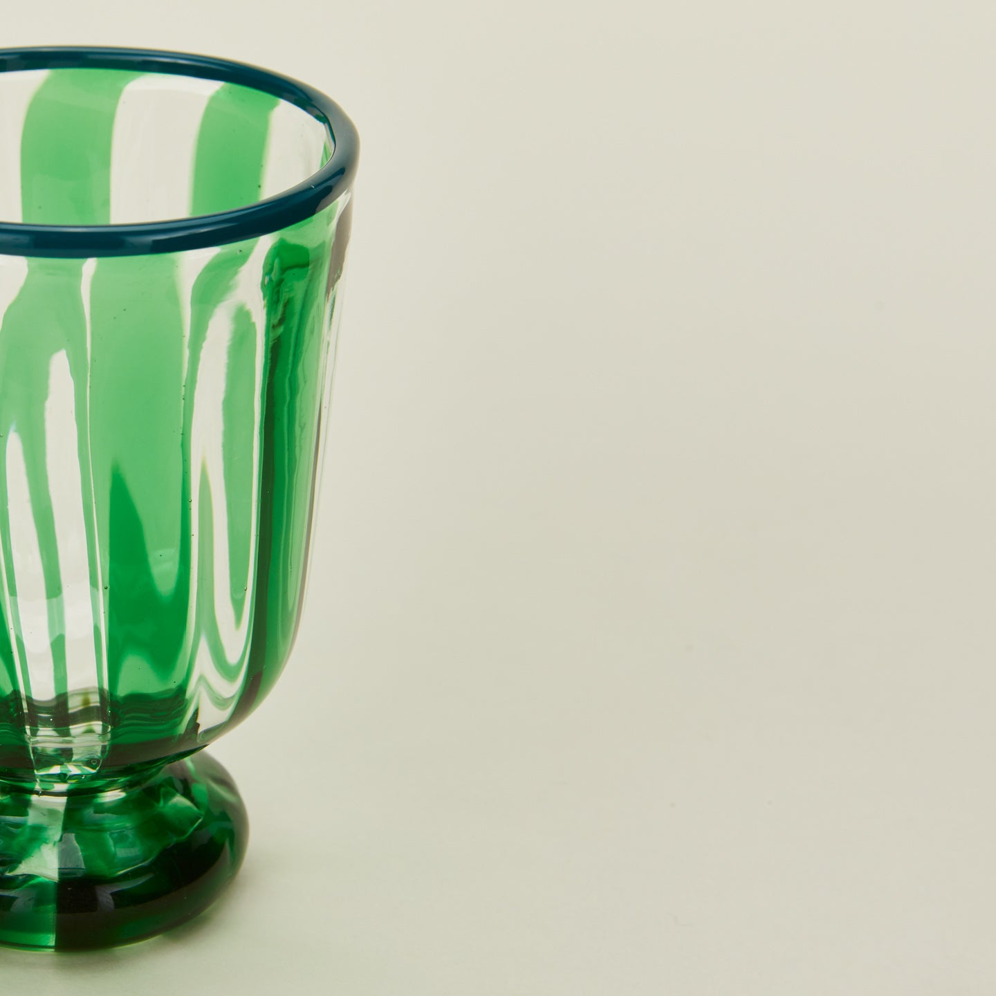 Close up view of striped wine glass in green