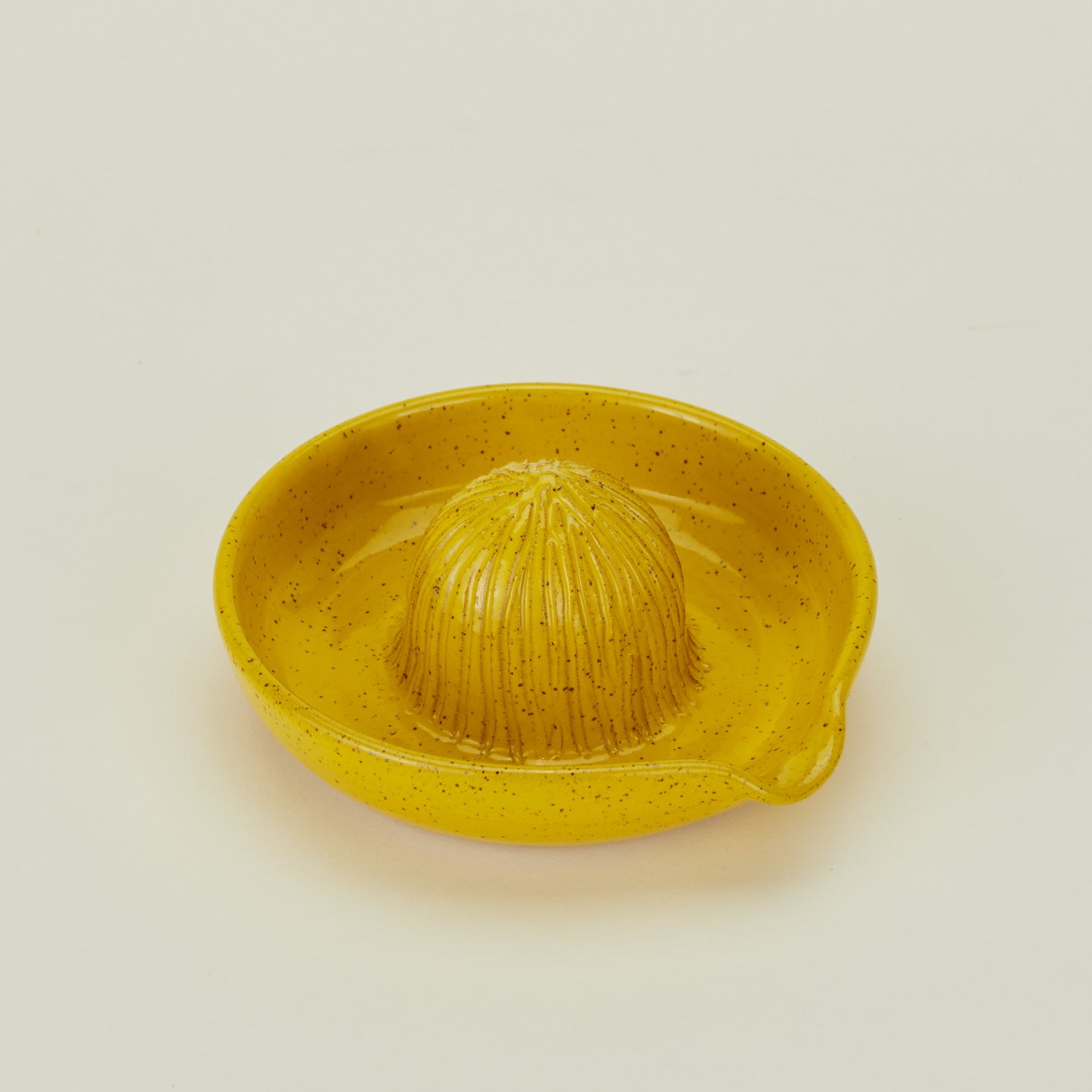 Three-quarter angle of stoneware citrus juicer in Yellow.