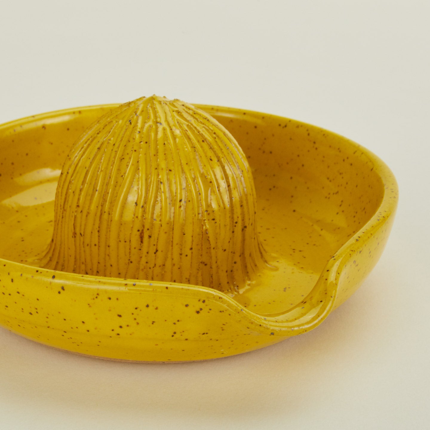 Close up of stoneware citrus juicer in Yellow.