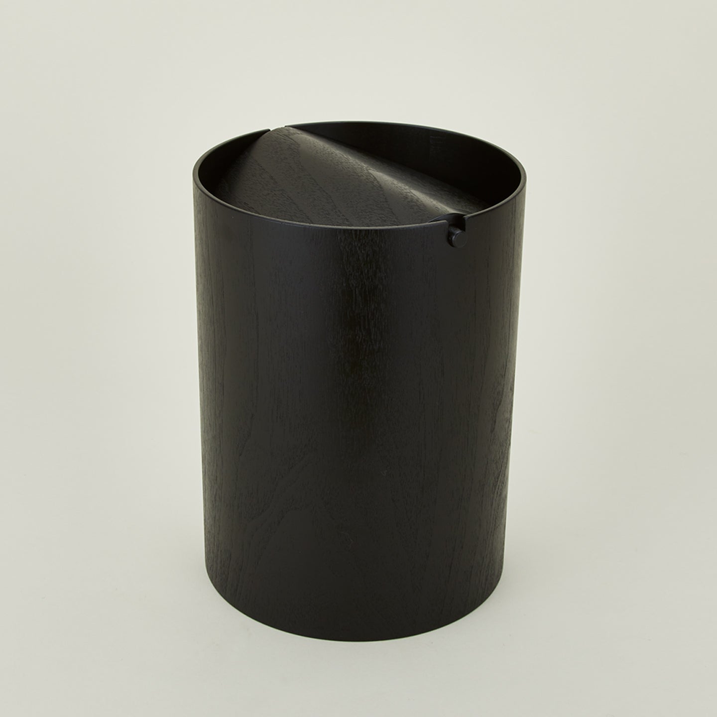 Lidded wooden waste basket in dark