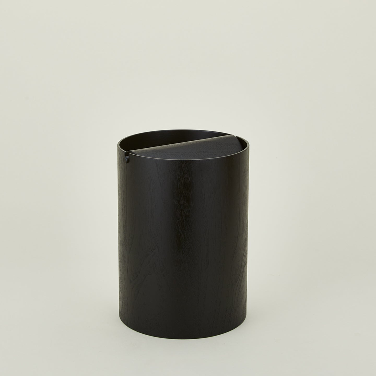 Lidded wooden waste basket in dark