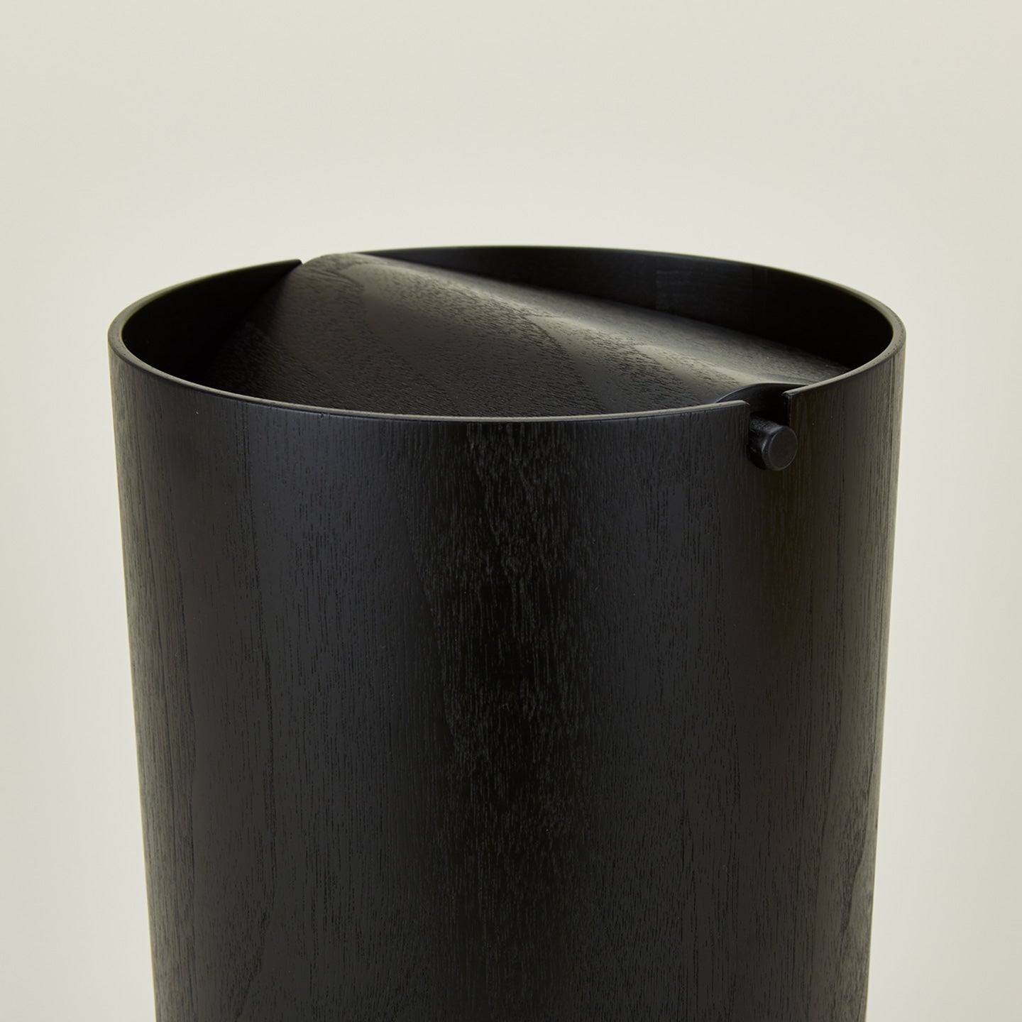 Close up view of lidded wooden waste basket in dark