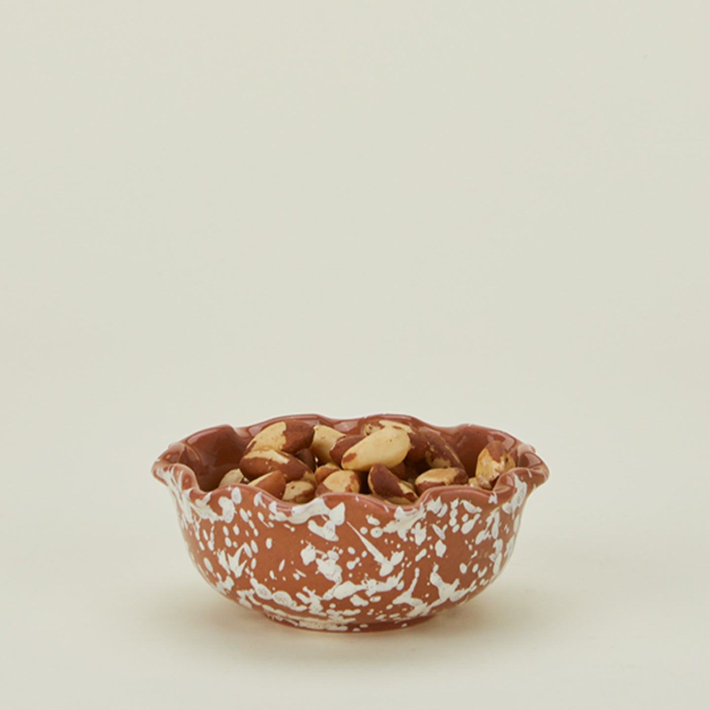 Splatter scallop bowl in terracotta and ivory with snack mix