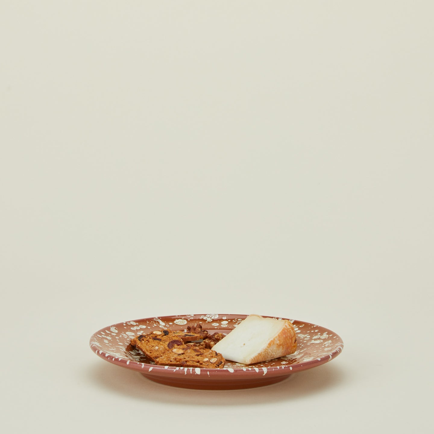 Splatter dinner plate in terracotta and ivory with cheese and crackers