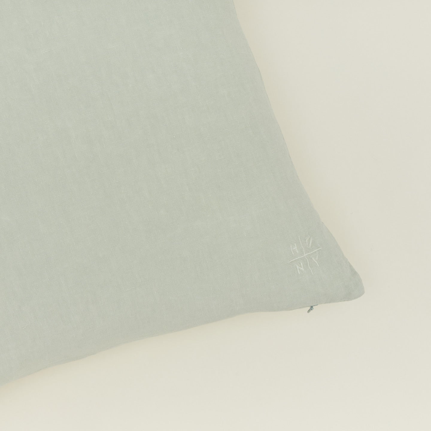 Close up view of simple linen pillow in sage