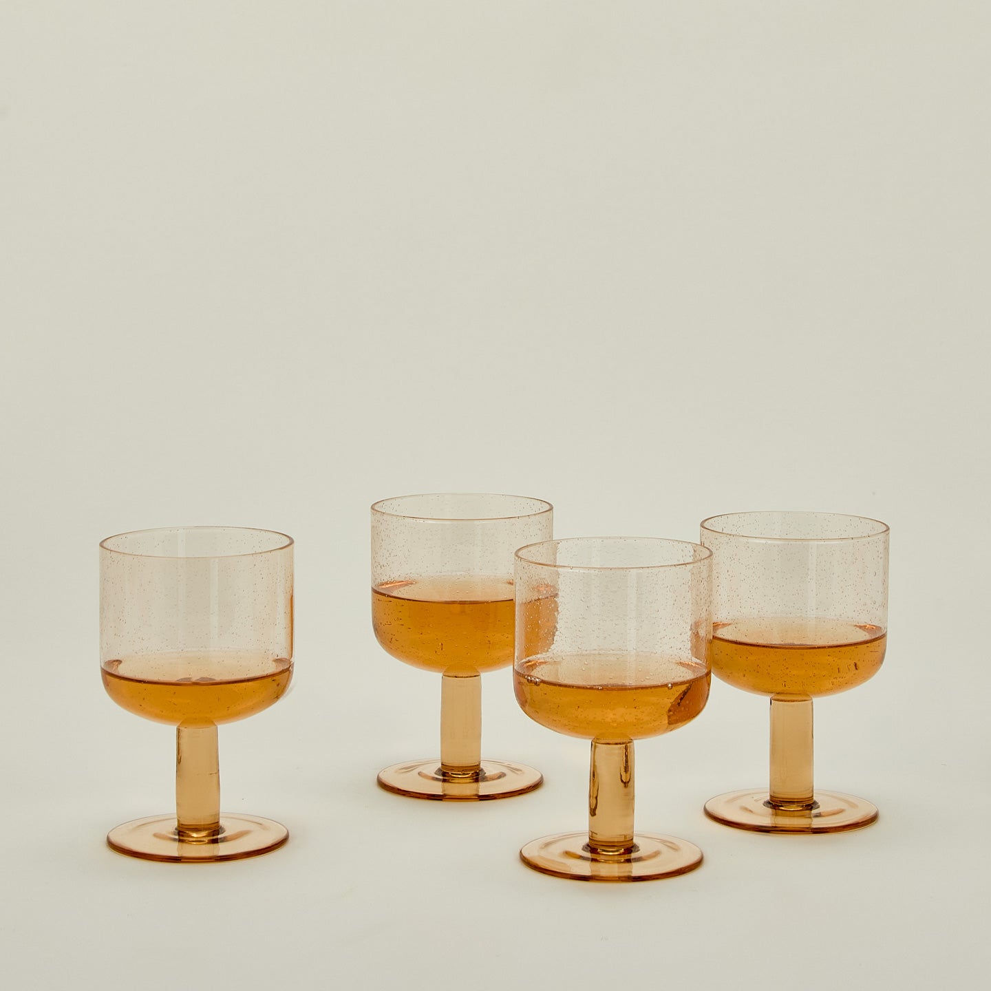 Simple seeded glassware in Peach with wine.