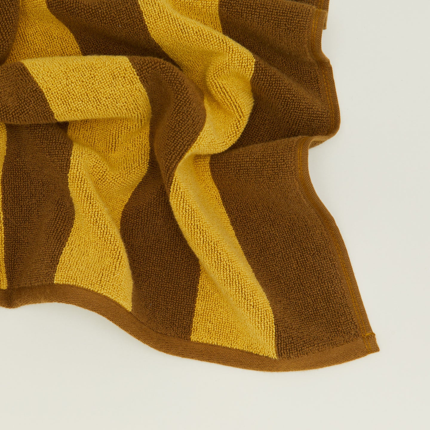 Close up of Simple Striped Terry Bath Mat in mustard and bronze.